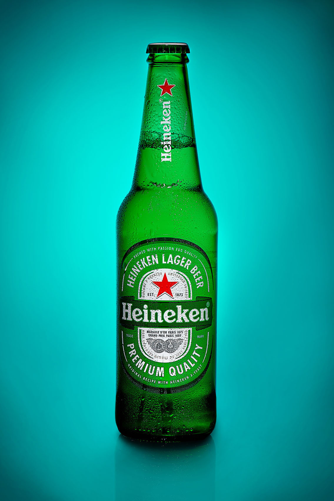 Бутылка пива из холодильника с капельками воды с цветной подсветкой