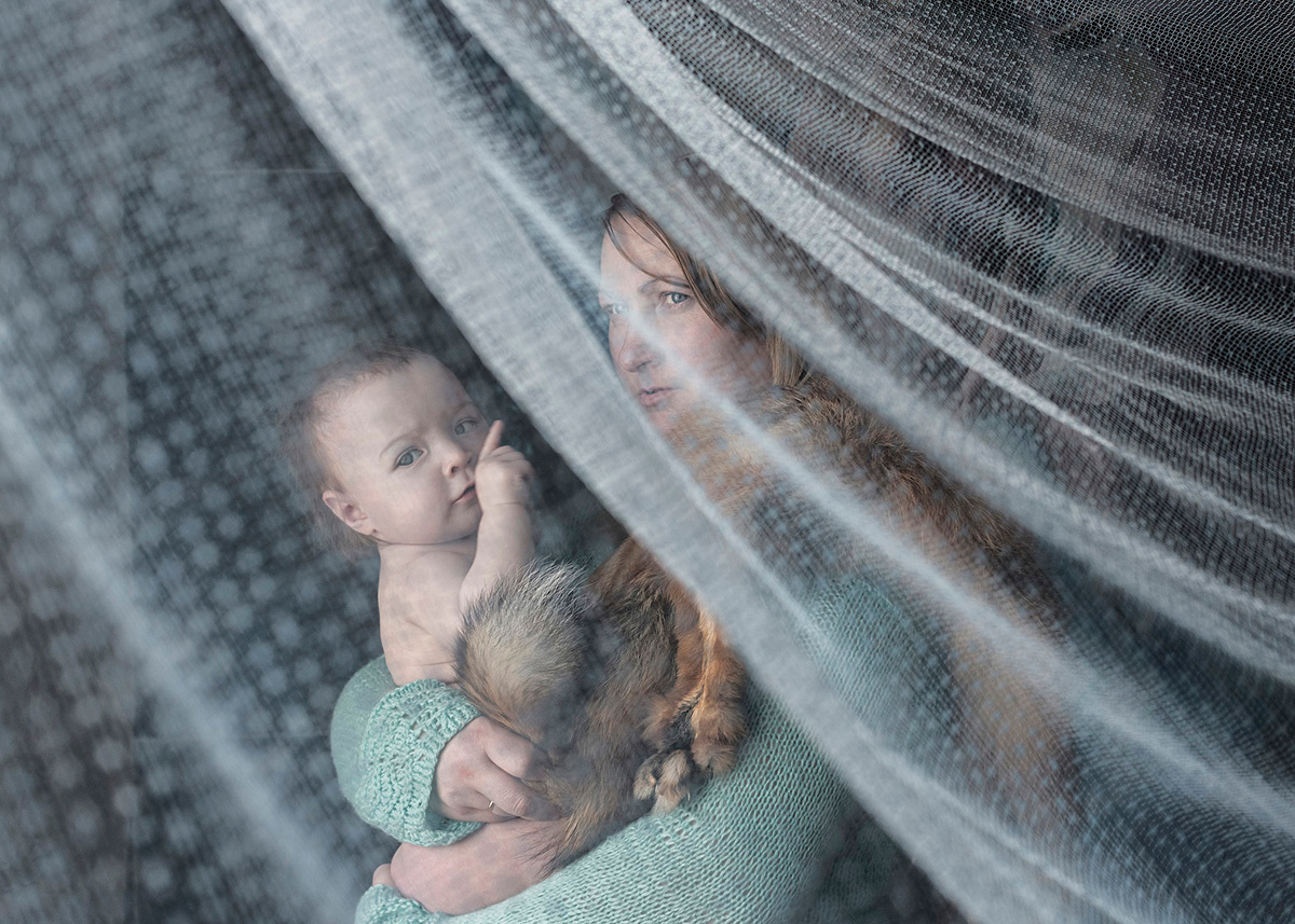 Valentina, mother of four is holding her daughter Varvara. Far North, Siberia by Elena Anosova