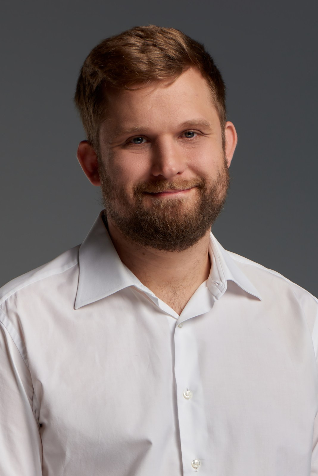 Деловой портрет мужчины на нейтральном фоне — открытый, уверенный образ.