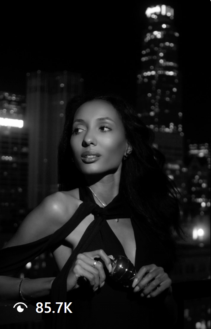 Mary Senn elegantly posing in a black dress for a Karl Lagerfeld perfume ad, with the Los Angeles skyline at night. A stunning blend of modern fashion and luxury branding.
