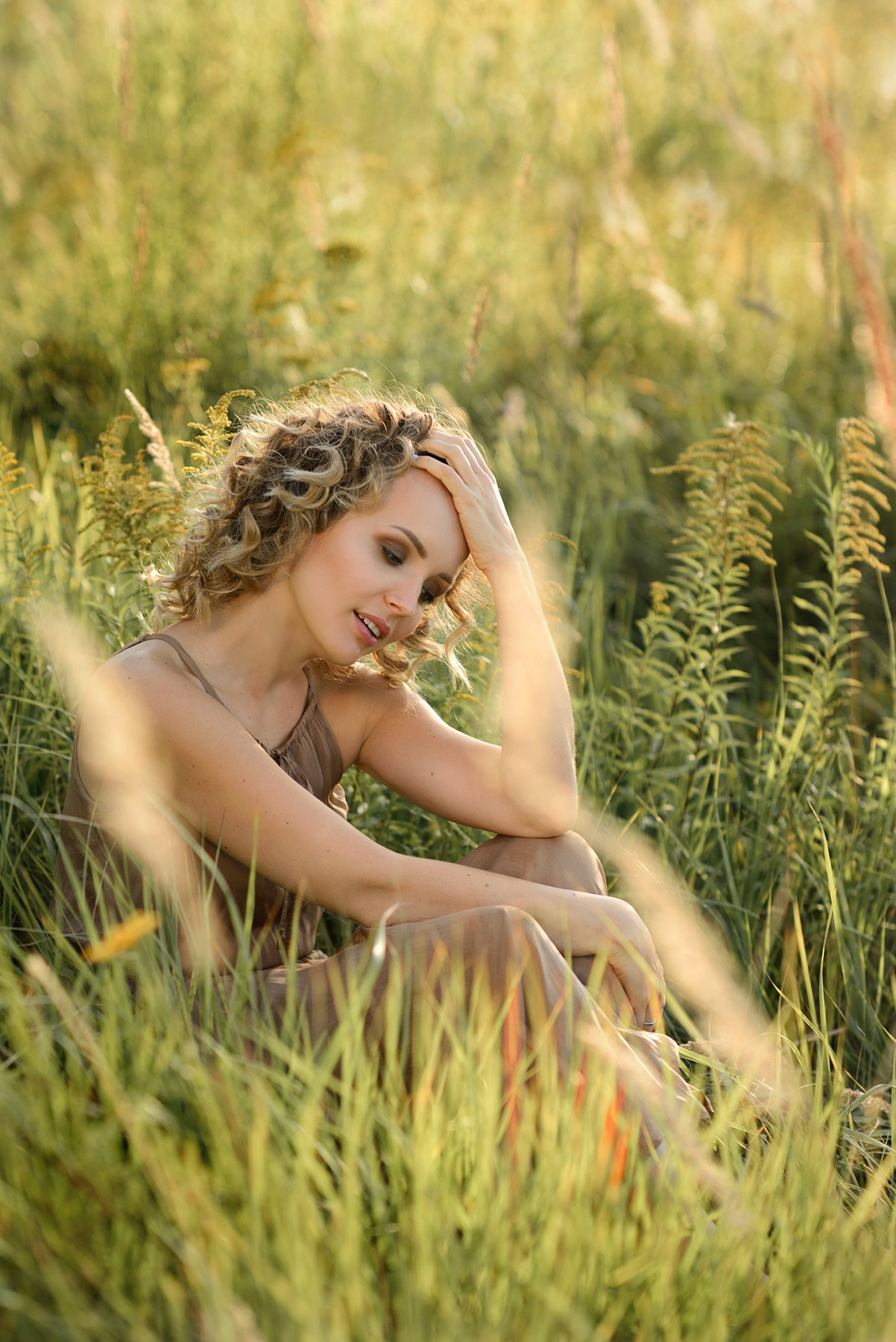 A photo shoot for a woman l in the field. Sunset photo shoot for a girl Curly hair style. (photographer in Edinburgh Elena)