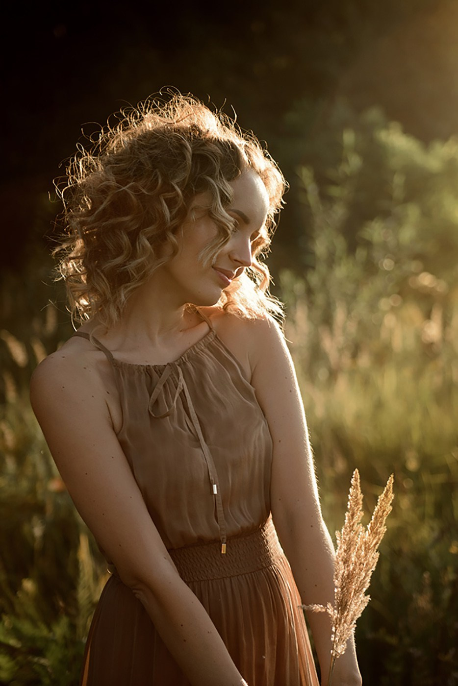 A photo shoot for a woman l in the field. Sunset photo shoot for a girl Curly hair style. (photographer in Edinburgh Elena)