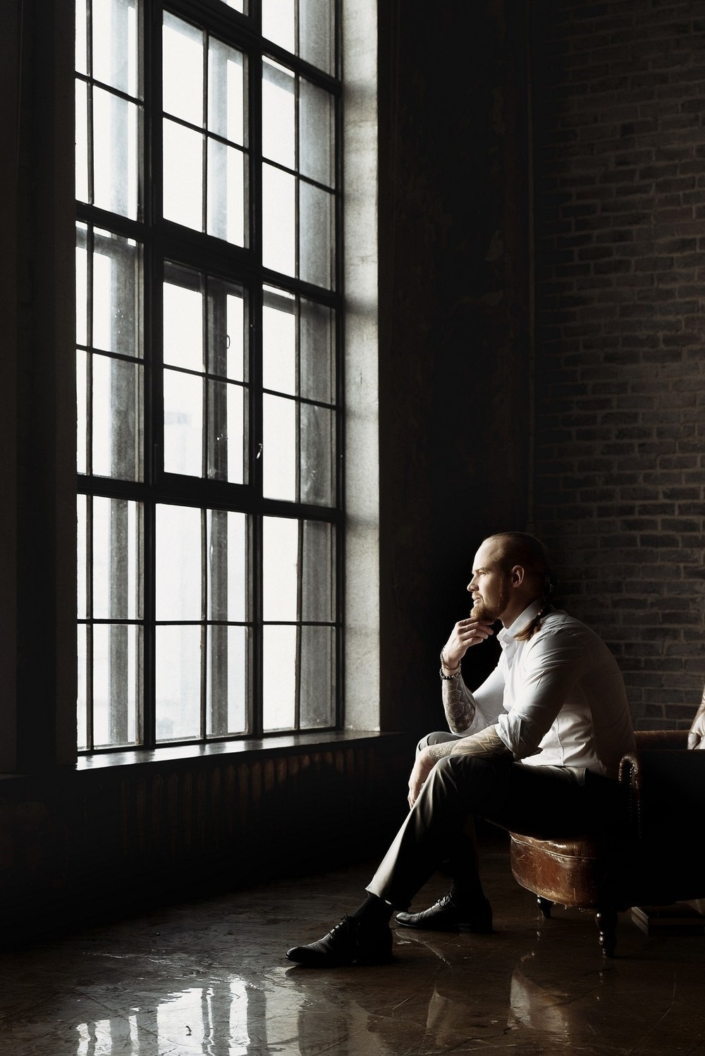 портрет сидящего в кресле жениха в жестком свете у большого окна Свадебная фотосъемка в Москве. Свадебный фотограф в Москве Сергей Гаварос. — Круто снимаю любые свадьбы! — Помогу с позированием и подбором локаций Доступные цены.