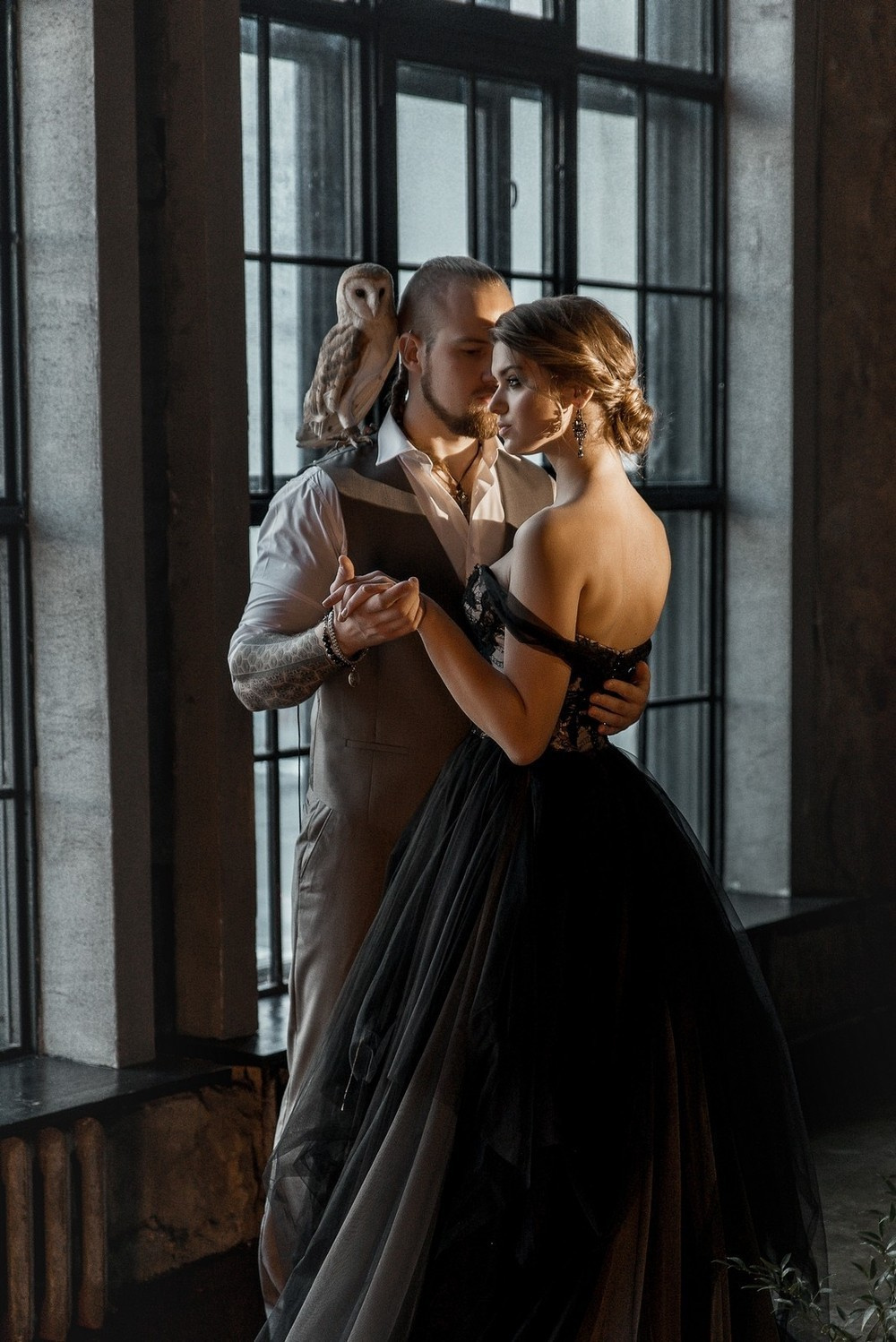 жених и невеста обнимаются у окна. на плече жениха сидит сова  Свадебная фотосъемка в Москве. Свадебный фотограф в Москве Сергей Гаварос.