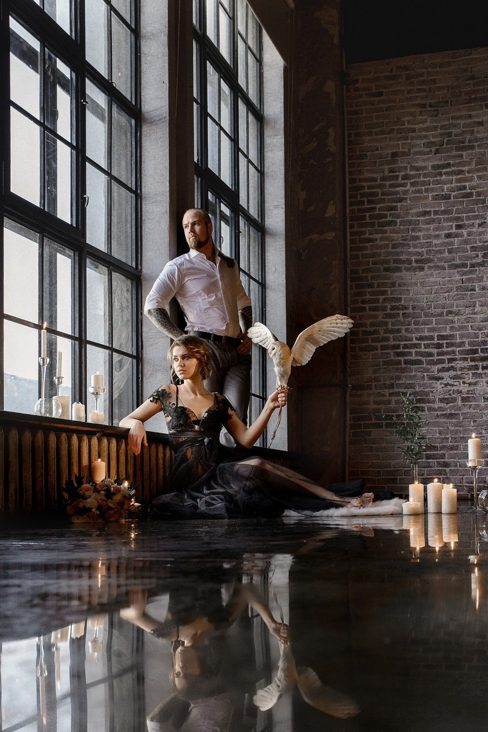 невеста сидит у окна с совой на плече на фоне стоящего за ней жениха Свадебная фотосъемка в Москве. Свадебный фотограф в Москве Сергей Гаварос.