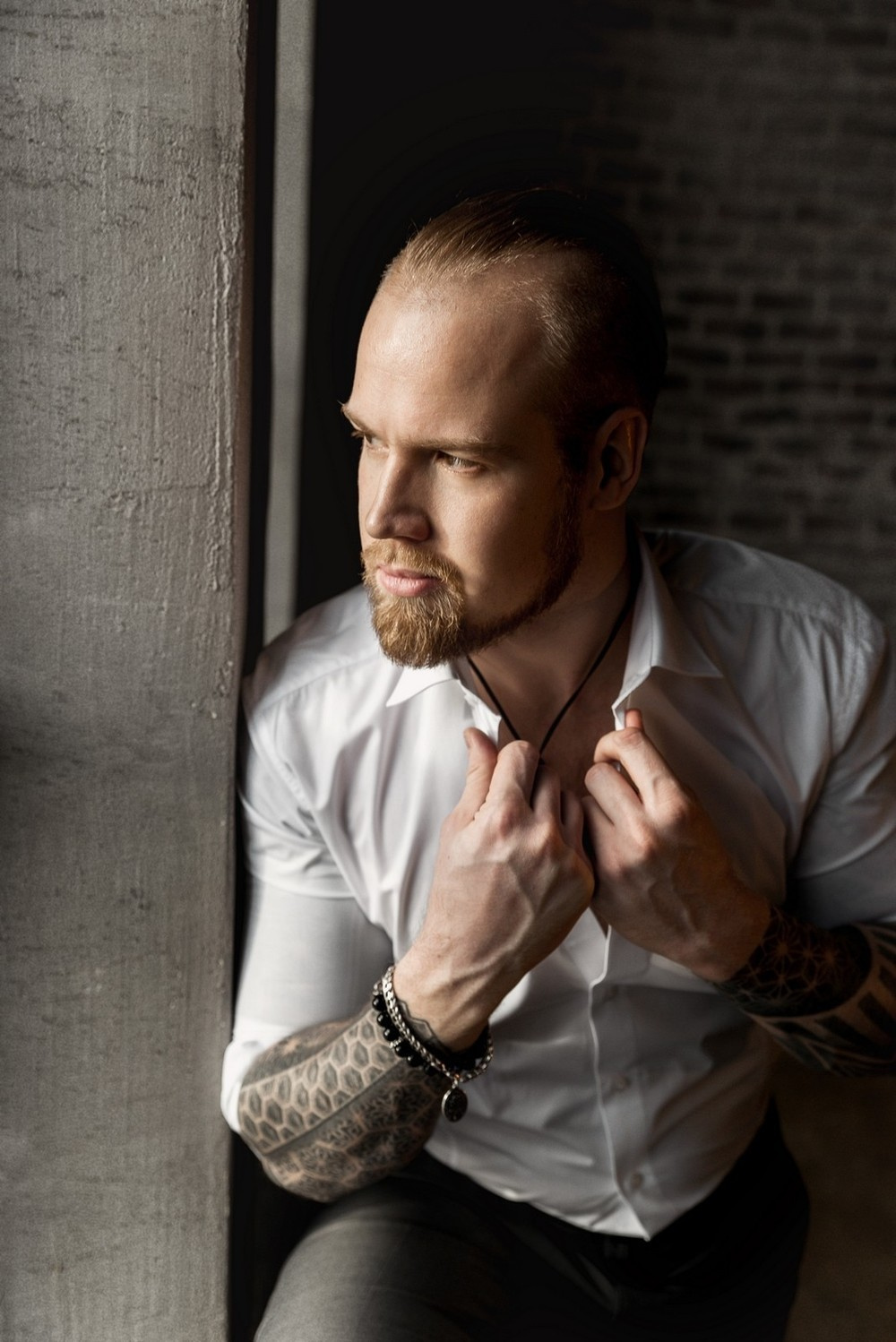 Жених в белой рубашке поправляет воротник и смотрит в окно.Свадебная фотосъемка в Москве. Свадебный фотограф в Москве Сергей Гаварос. — Круто снимаю любые свадьбы! — Помогу с позированием и подбором локаций Доступные цены.