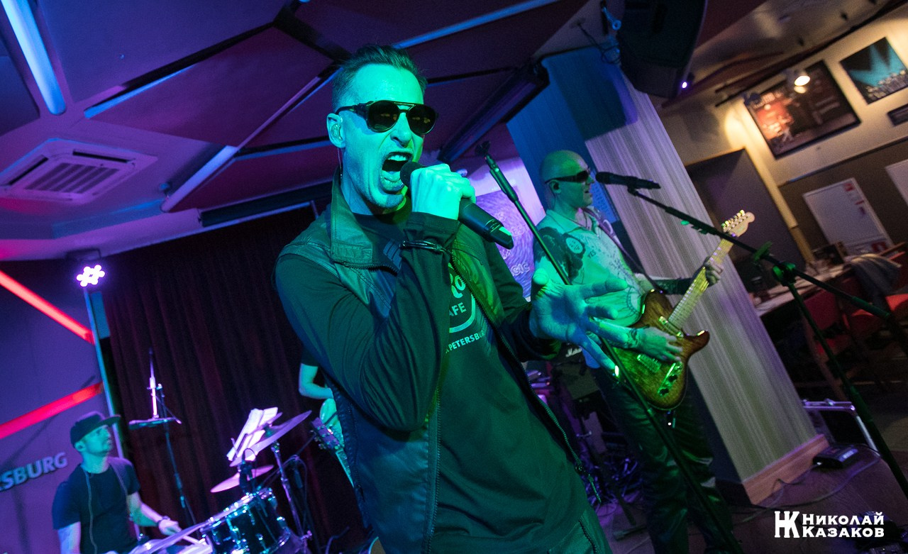 Солист группы Булдырдыш во время исполнения песни на сцене ресторана в цветном свете. Концерт группы Булдырдыш в ресторане THE Legends