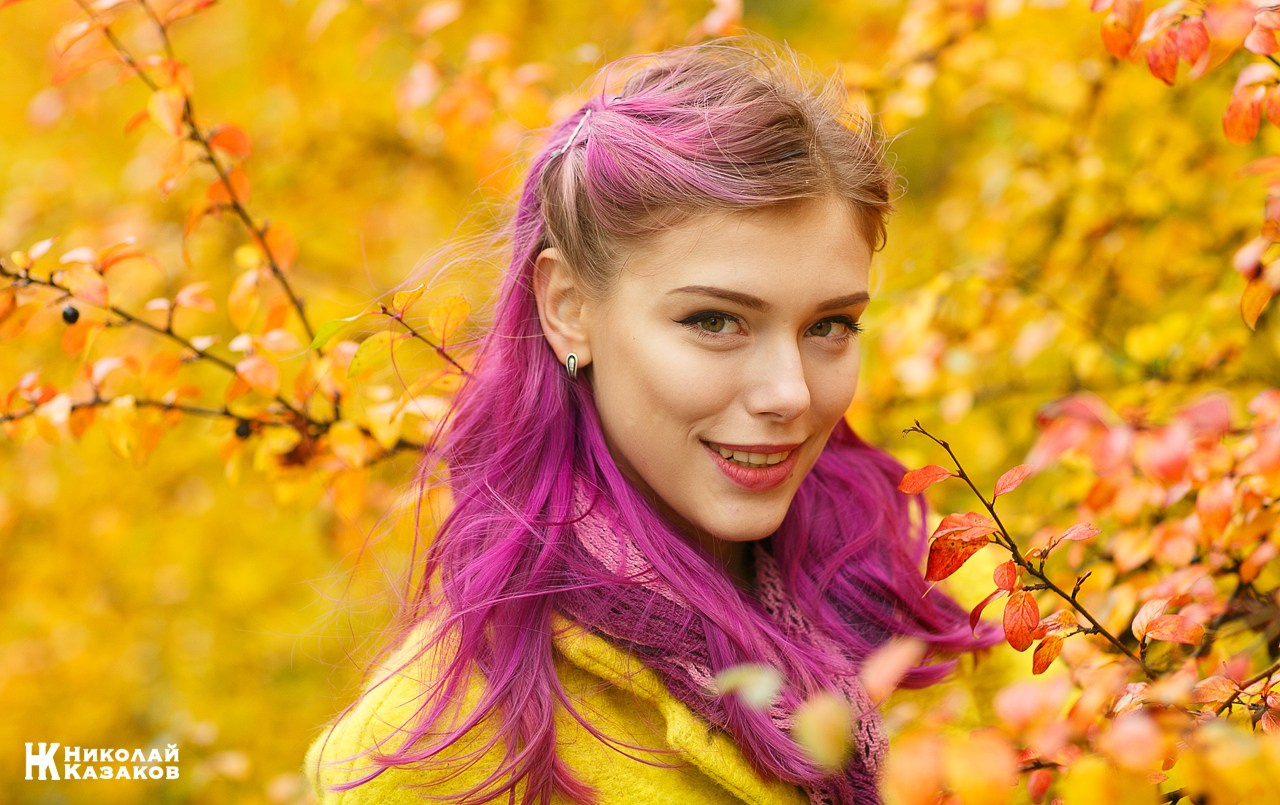 Стильная и яркая девушка среди желтых листьев во время фотопрогулки в парке