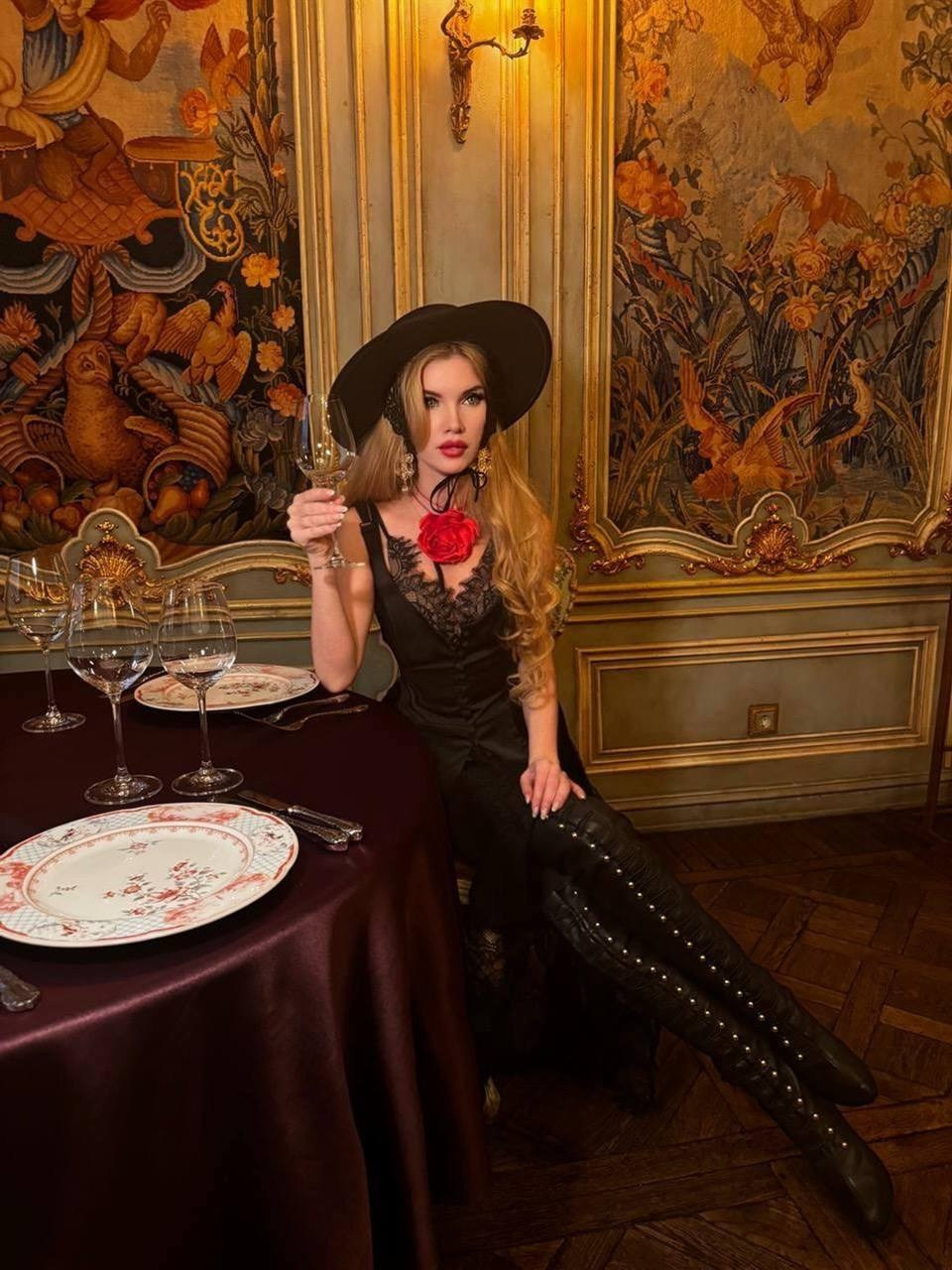 Фотосессия в ресторане Турандот девушки с черной шляпе с пустым бокалом в руке