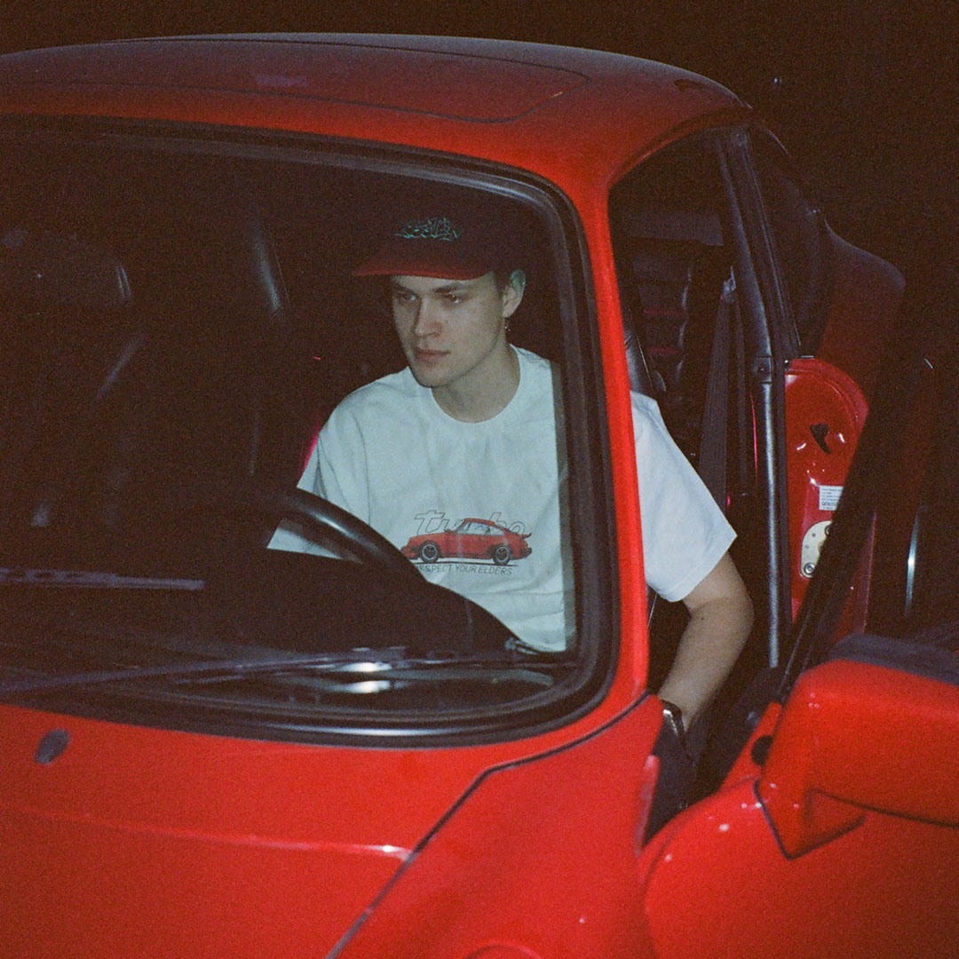 Мужчина за рулем красного Porsche 911 turbo