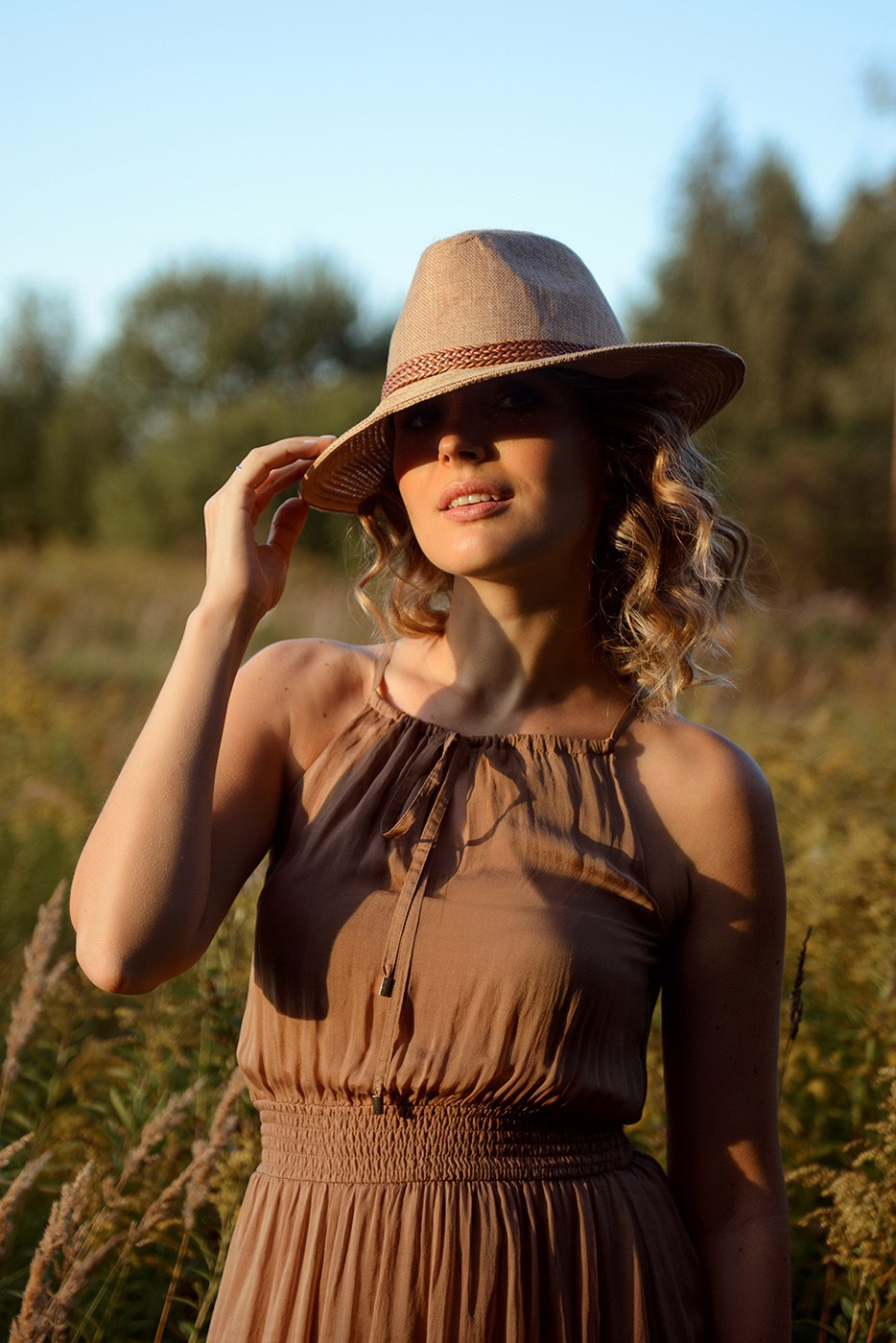 A photo shoot for a woman l in the field. Sunset photo shoot for a girl Curly hair style. (photographer in Edinburgh Elena)