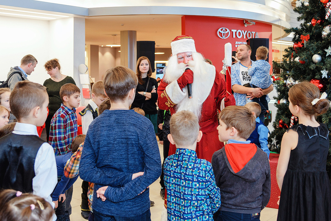 Дед Мороз общается с детьми возле новогодней ёлки.