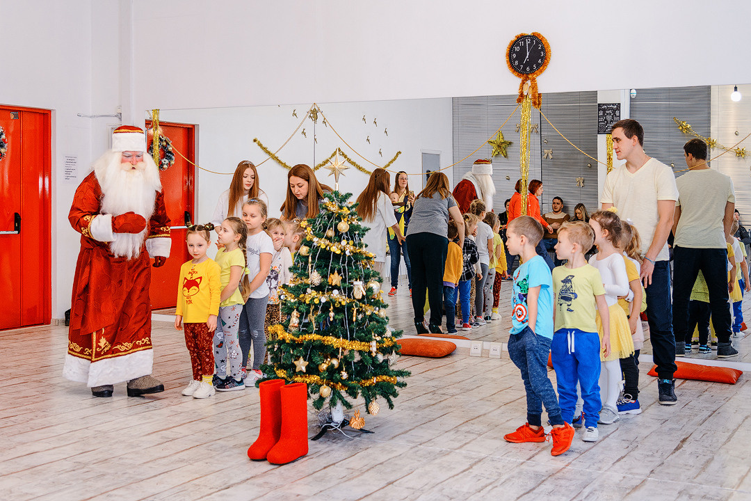 Дед Мороз проводит конкурс для детей возле новогодней ёлки.