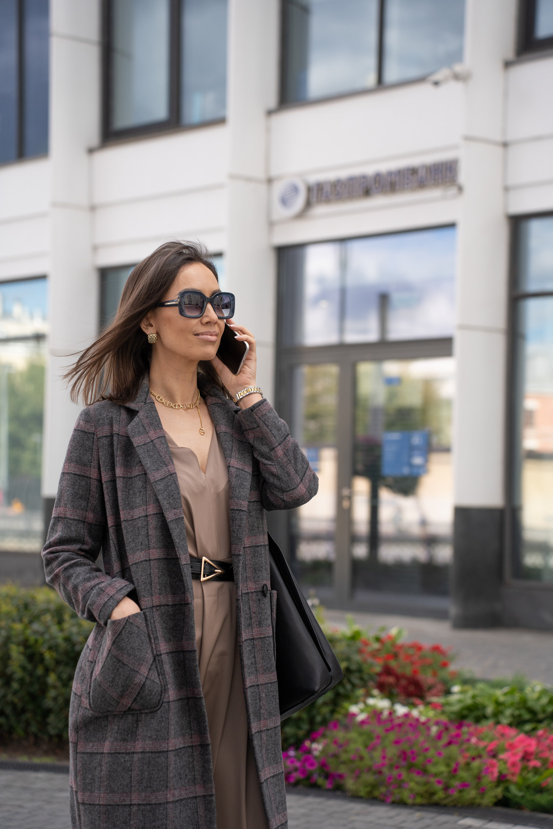 девушка говорит по телефону на фоне здания