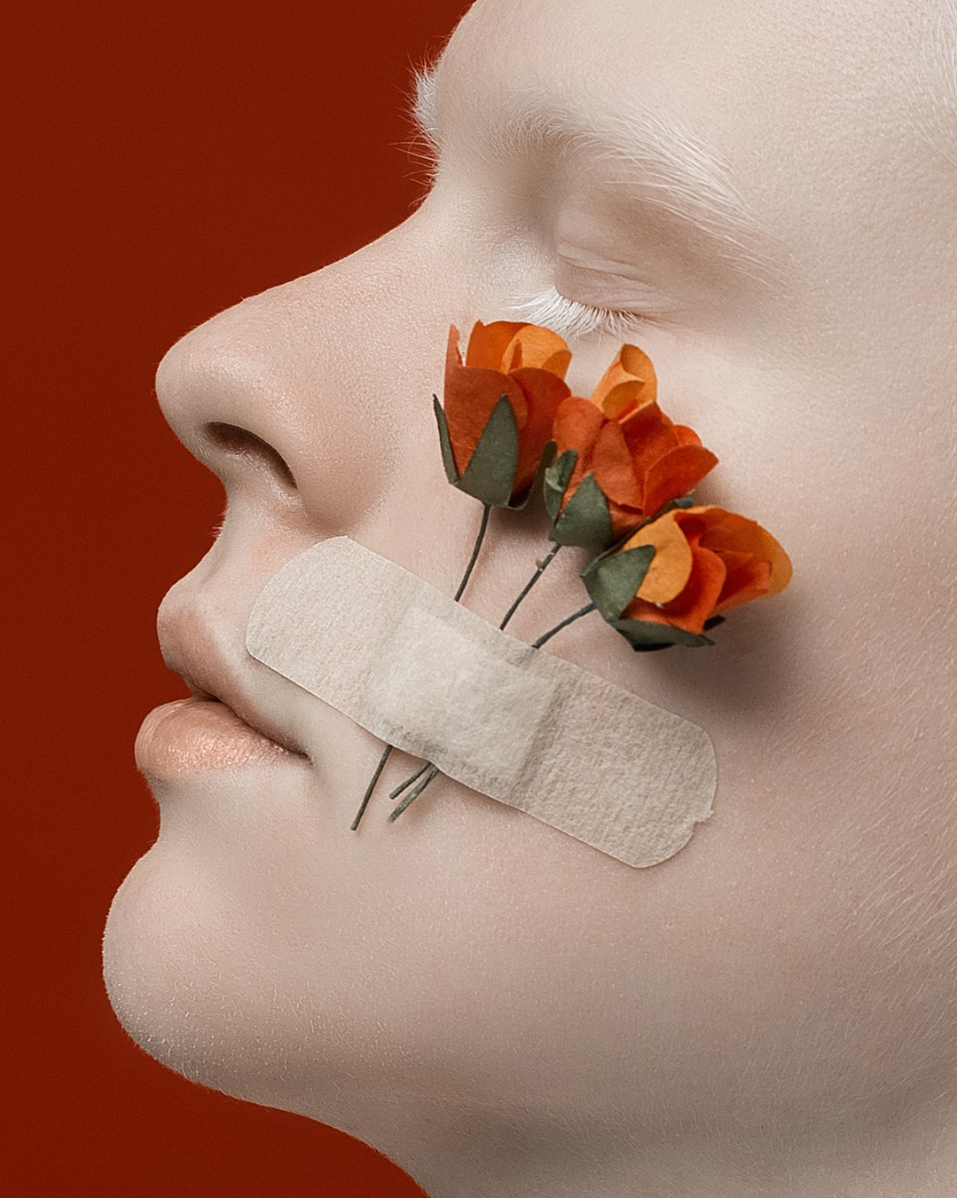 Альбинос на красном фоне на лице декоративные цветы, альбинос с цветами на лице Казань