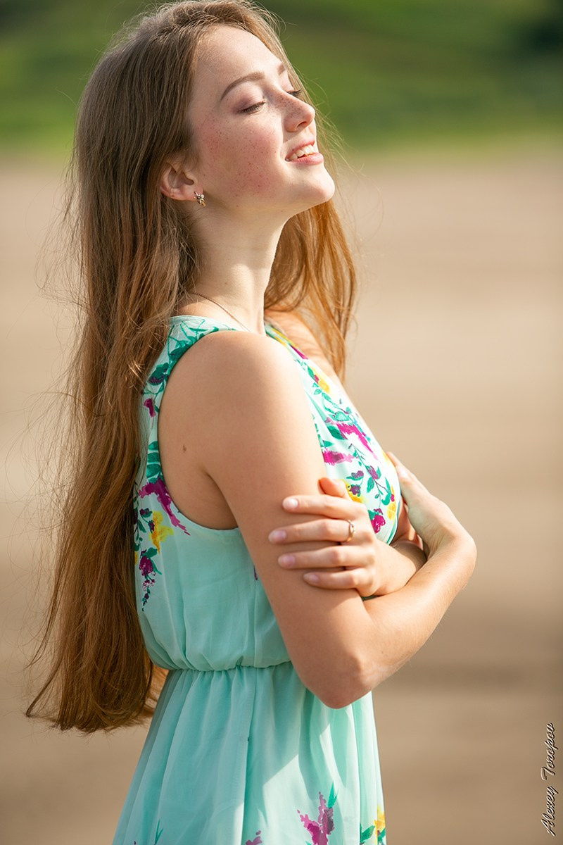 Девушка наслаждается солнцем в бирюзовом платье