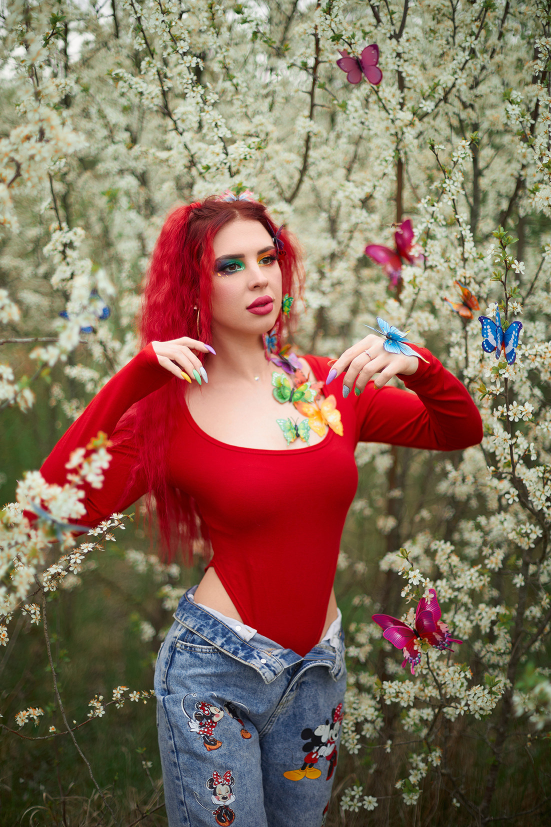 Девушка с красными волосами, ярким макияжем и разноцветными бабочками в цветущем саду. Фотограф. Тимашевск. Кубань. Краснодарский край.