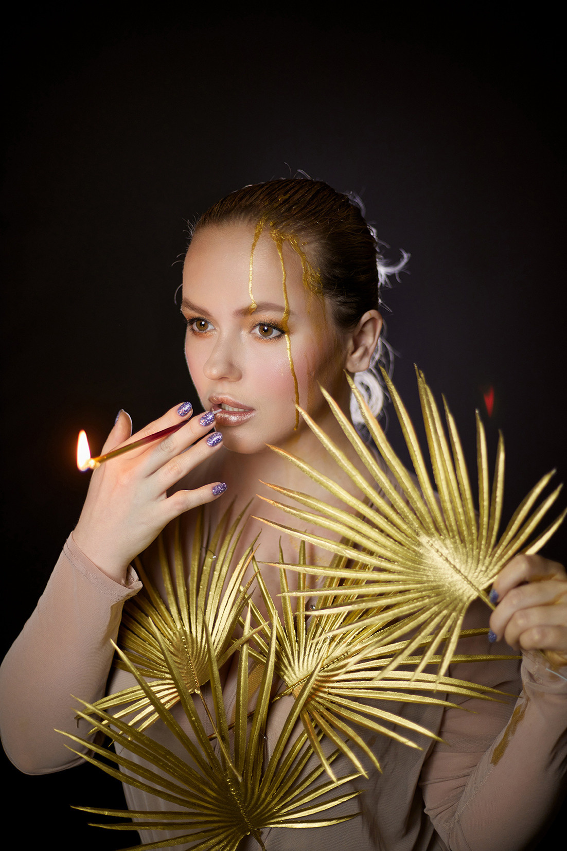 Девушка с золотой пальмовой веткой и на черном фоне. Девушка с жидким золотом на лице курит свечу от торта. Фотограф. Тимашевск. Кубань. Краснодарский край. Москва. Фотограф в Москве.