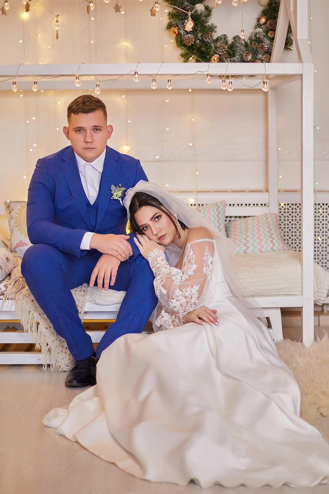 Невеста и жених сидят на кровати в фотостудии. Фотограф. Тимашевск. Кубань. Краснодарский край.