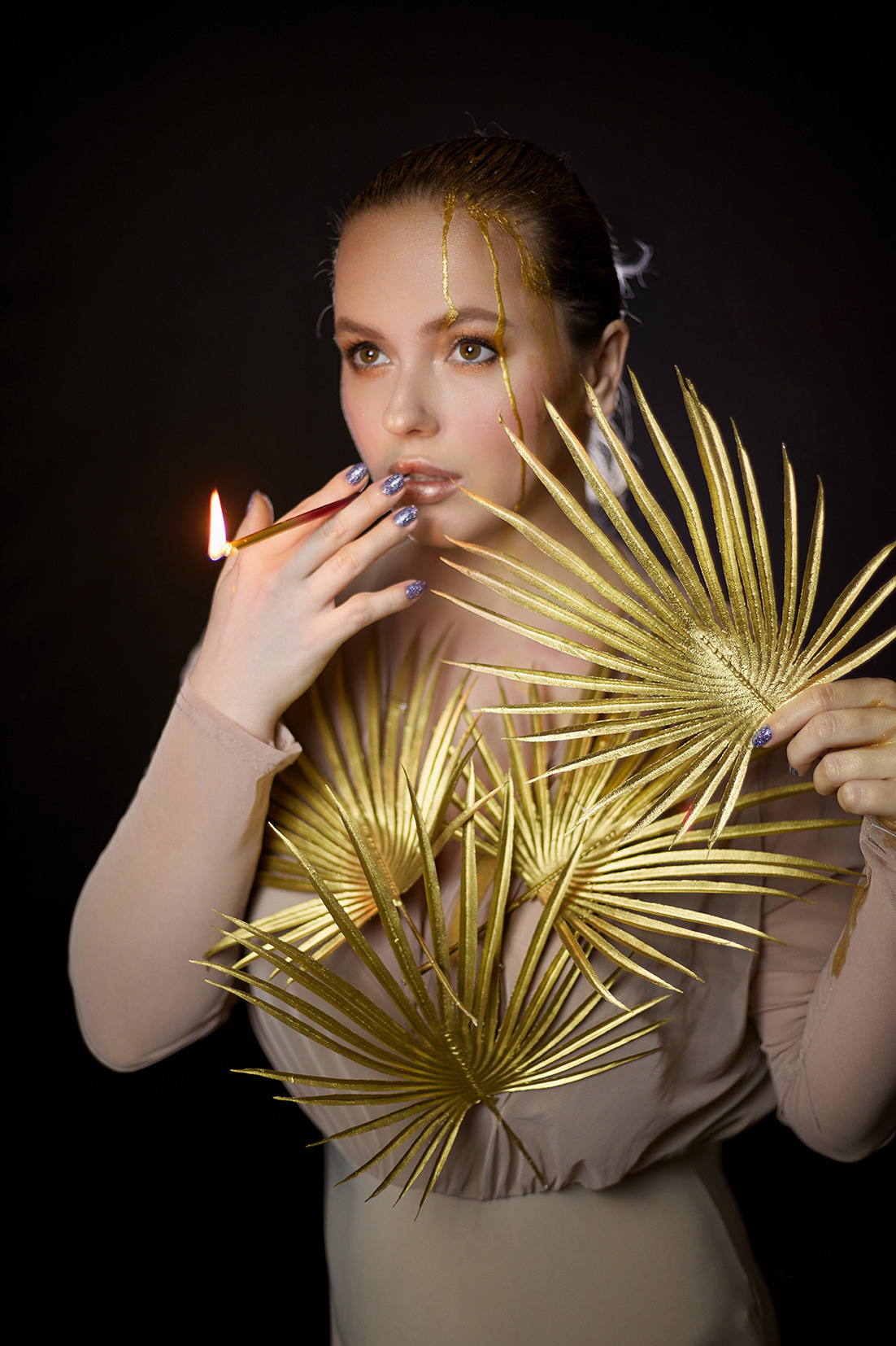 Девушка с золотой пальмовой веткой и на черном фоне. Девушка с жидким золотом на лице курит свечу от торта. Фотограф. Тимашевск. Кубань. Краснодарский край. Москва. Фотограф в Москве.
