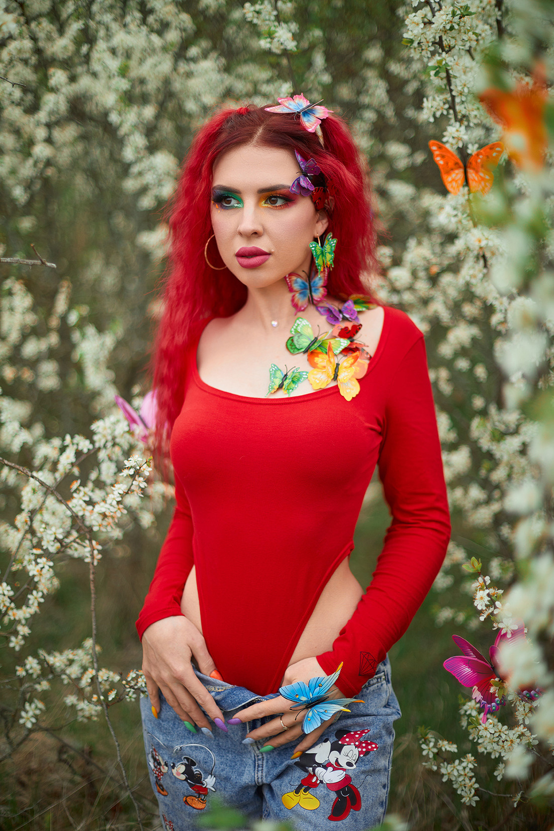 Девушка с красными волосами, ярким макияжем и разноцветными бабочками в цветущем саду. Фотограф. Тимашевск. Кубань. Краснодарский край.