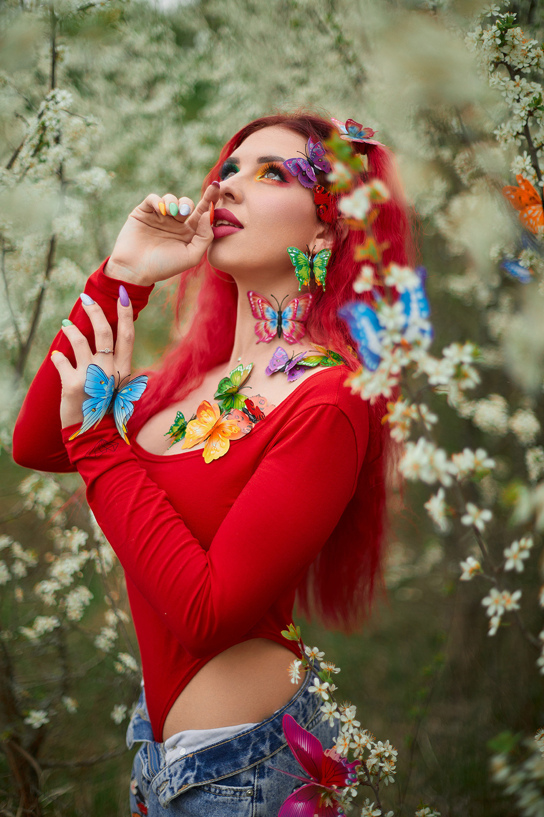 Девушка с красными волосами, ярким макияжем и разноцветными бабочками в цветущем саду. Фотограф. Тимашевск. Кубань. Краснодарский край.