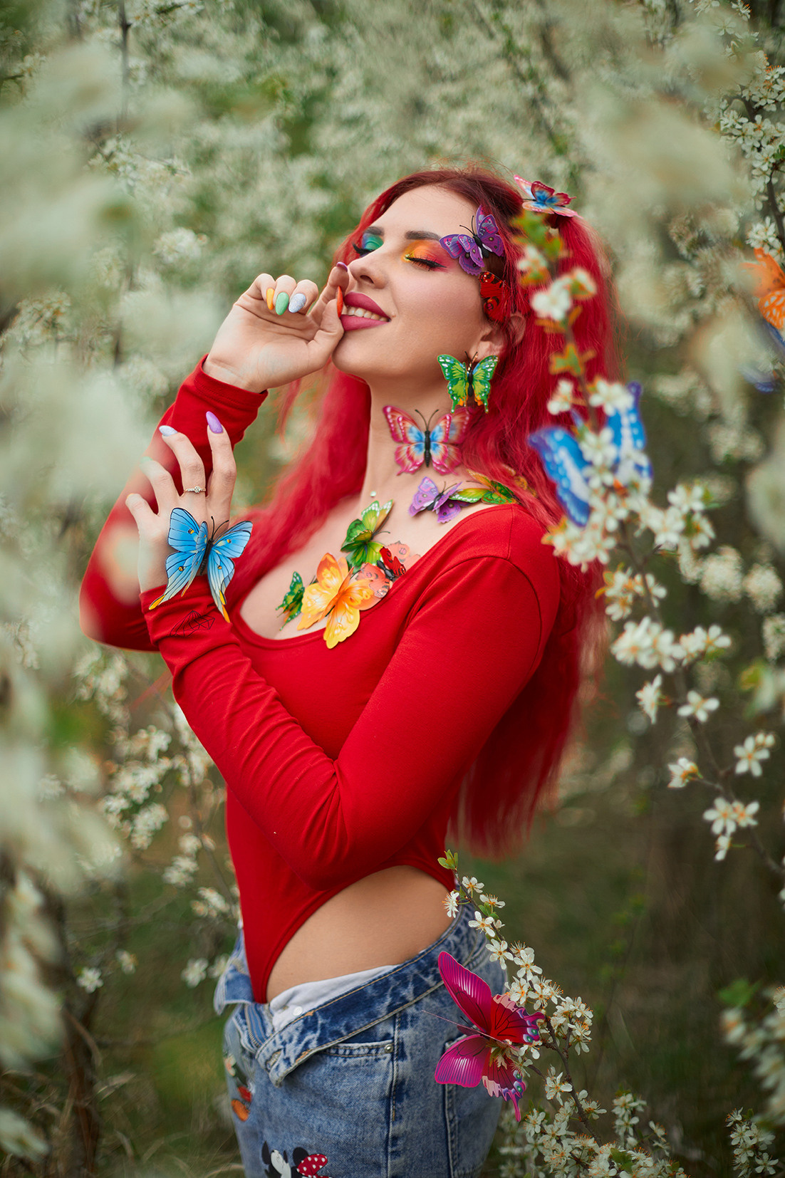 Девушка с красными волосами, ярким макияжем и разноцветными бабочками в цветущем саду. Фотограф. Тимашевск. Кубань. Краснодарский край.