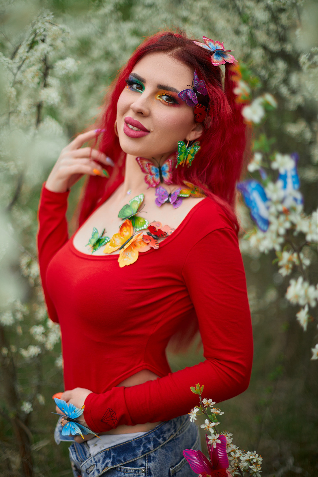 Девушка с красными волосами, ярким макияжем и разноцветными бабочками в цветущем саду. Фотограф. Тимашевск. Кубань. Краснодарский край.