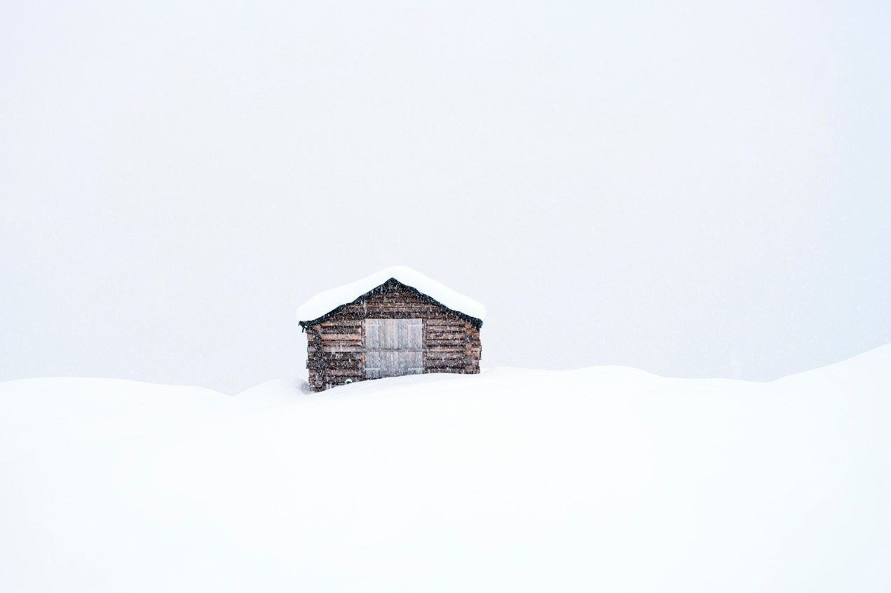 Isolated wooden hut surrounded by untouched snow.
