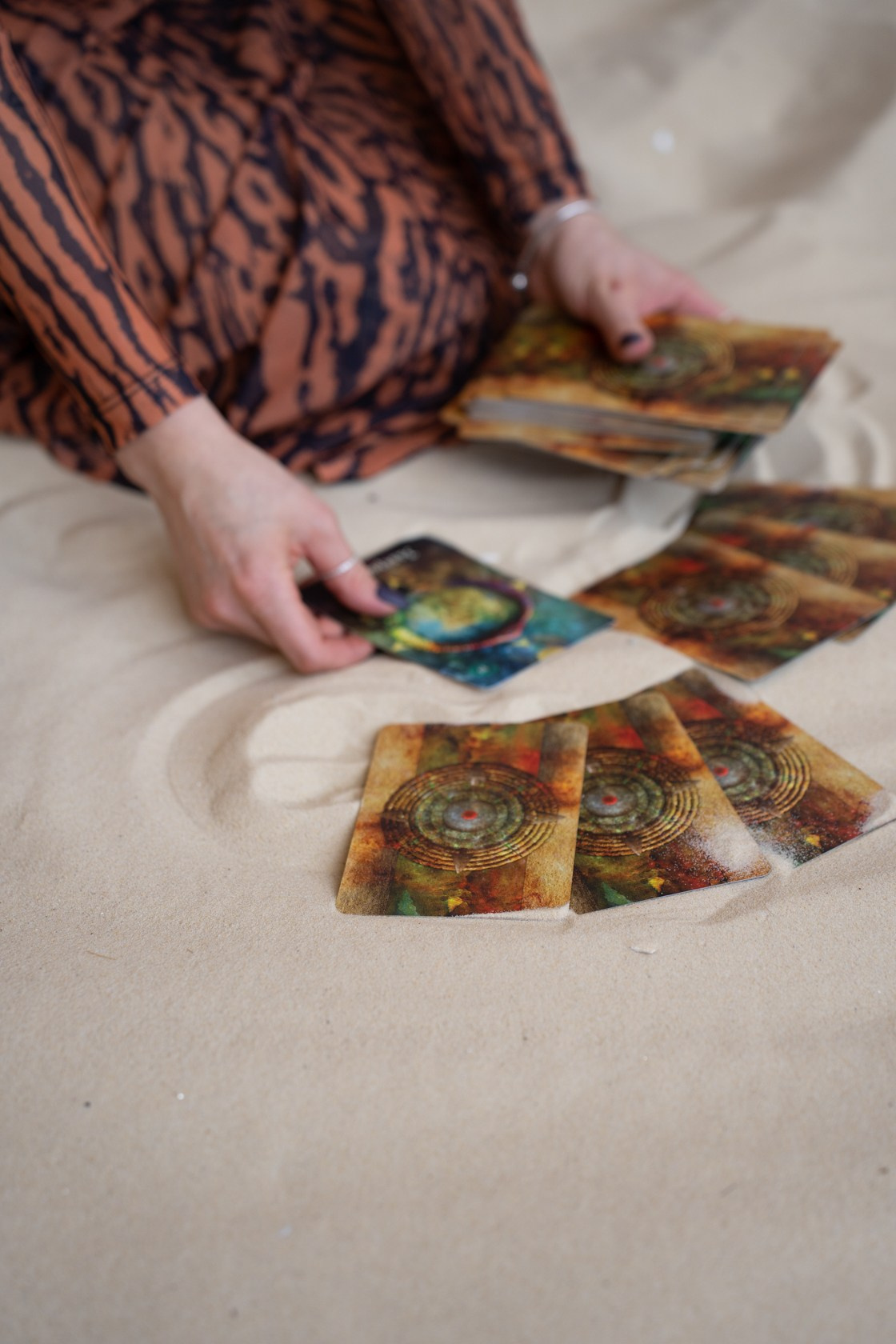 женские руки раскладывают карты таро