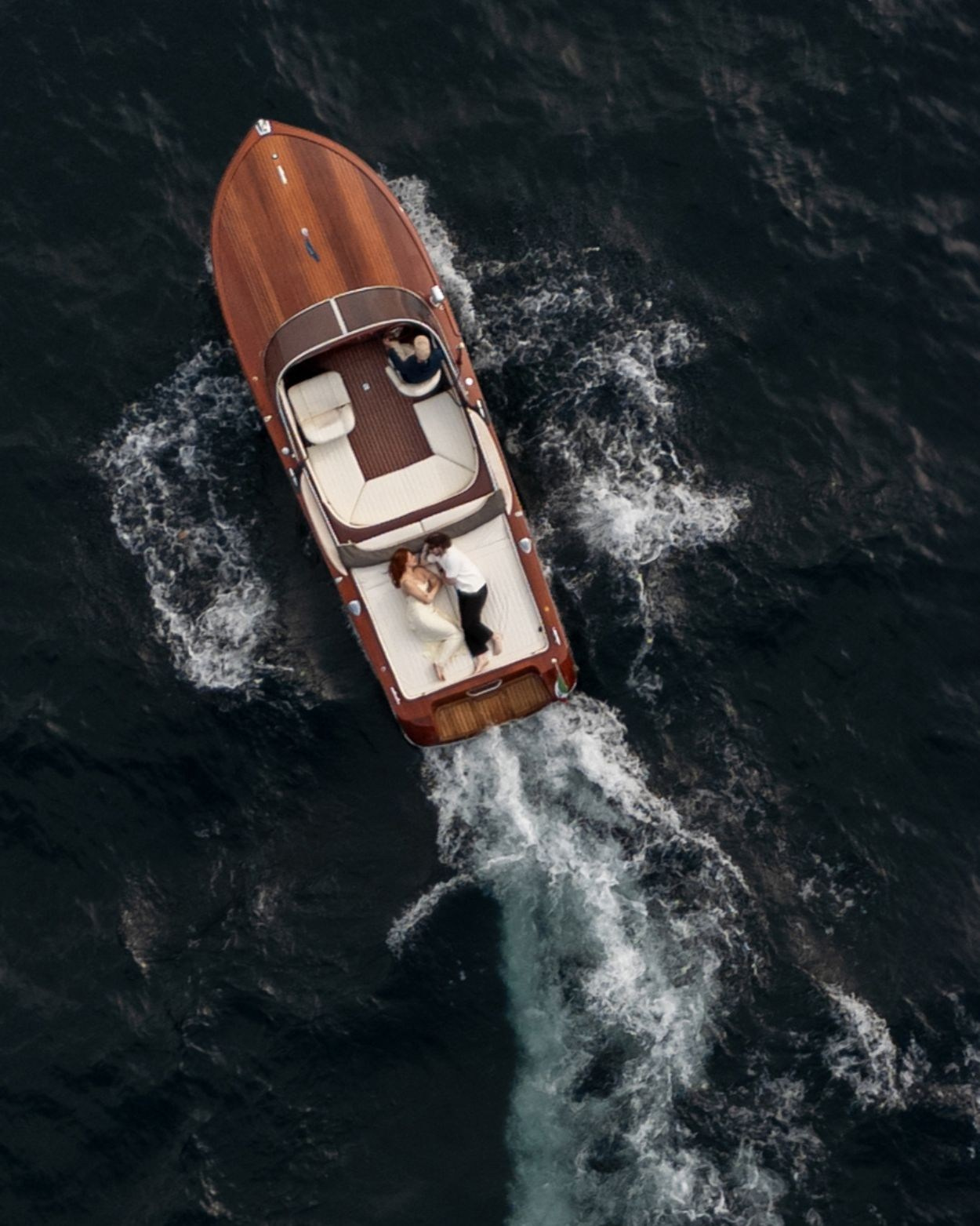 alt="Luxury wooden Riva boat cruising Lake Como with stylish couple onboard"