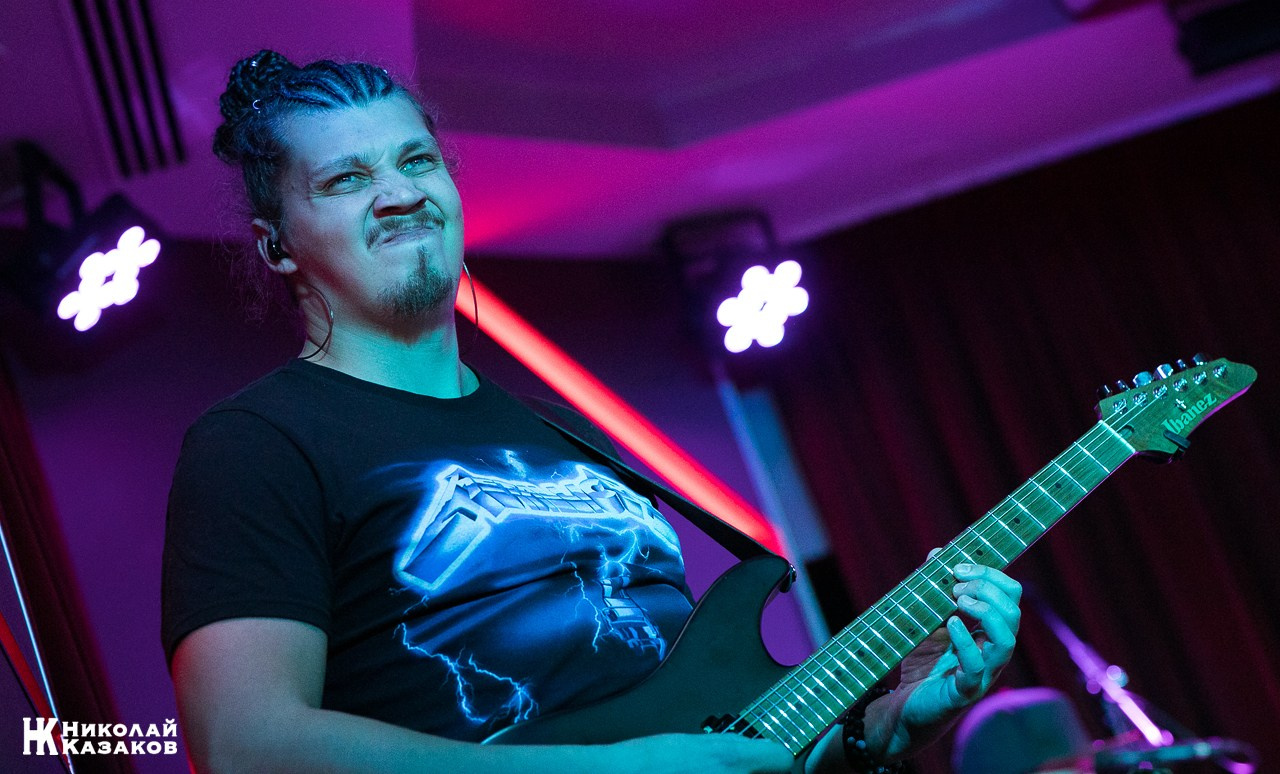 Гитарист рок группы с гримасой на лице во время высупления в клубе. Концерт группы Булдырдыш в ресторане THE Legends