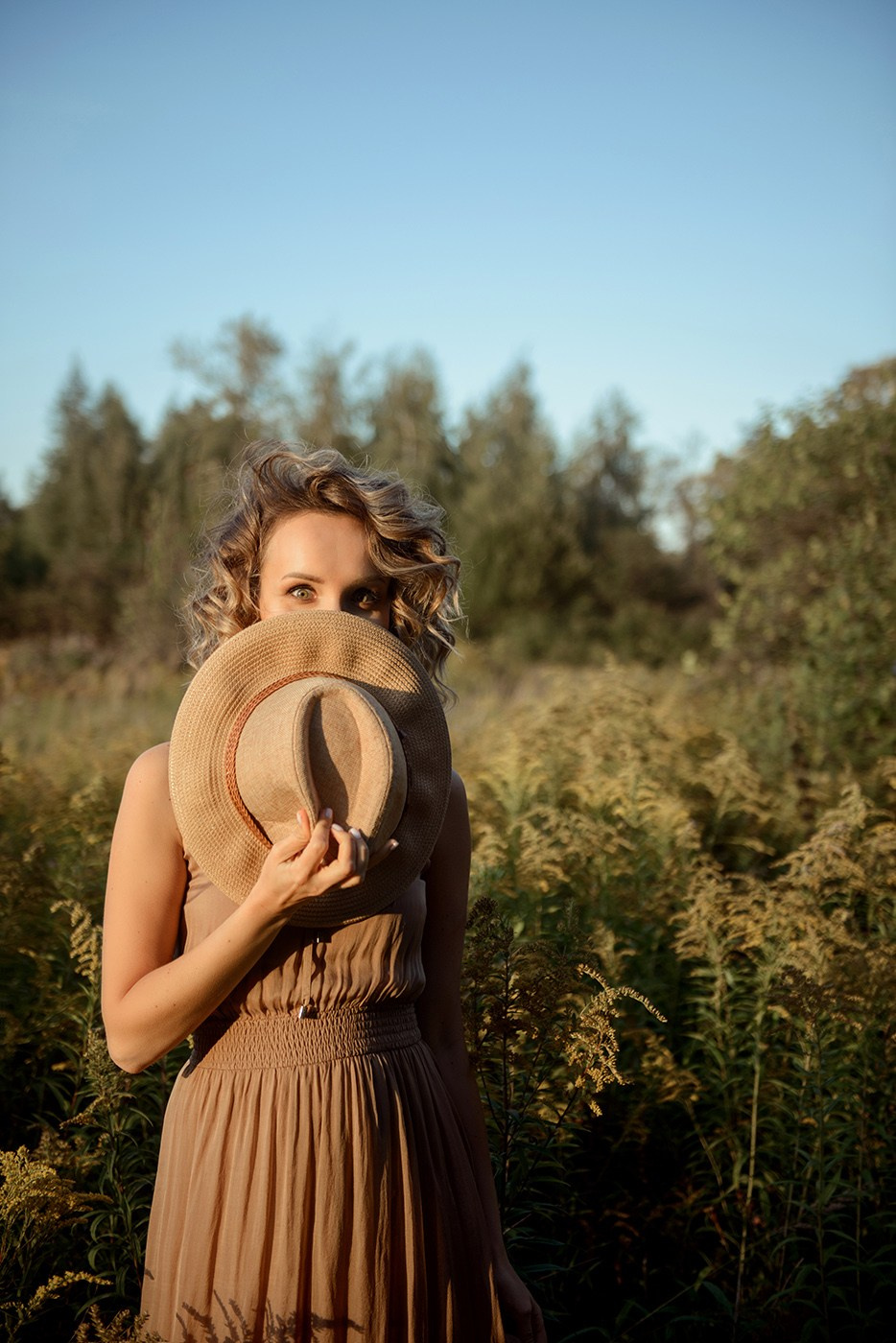 A photo shoot for a woman l in the field. Sunset photo shoot for a girl Curly hair style. (photographer in Edinburgh Elena)