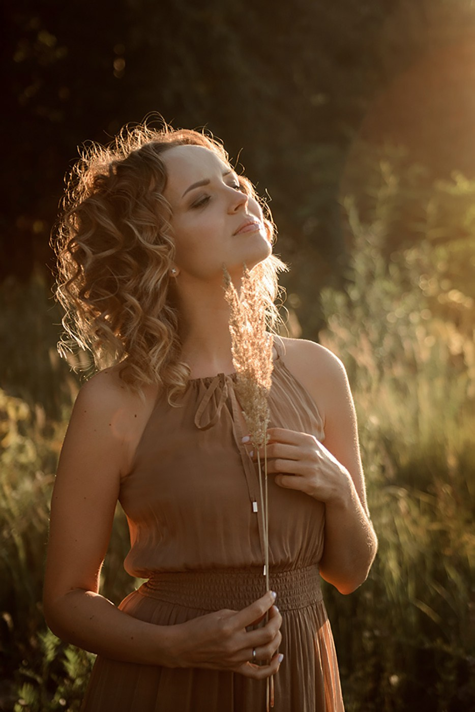 A photo shoot for a woman l in the field. Sunset photo shoot for a girl Curly hair style. (photographer in Edinburgh Elena)