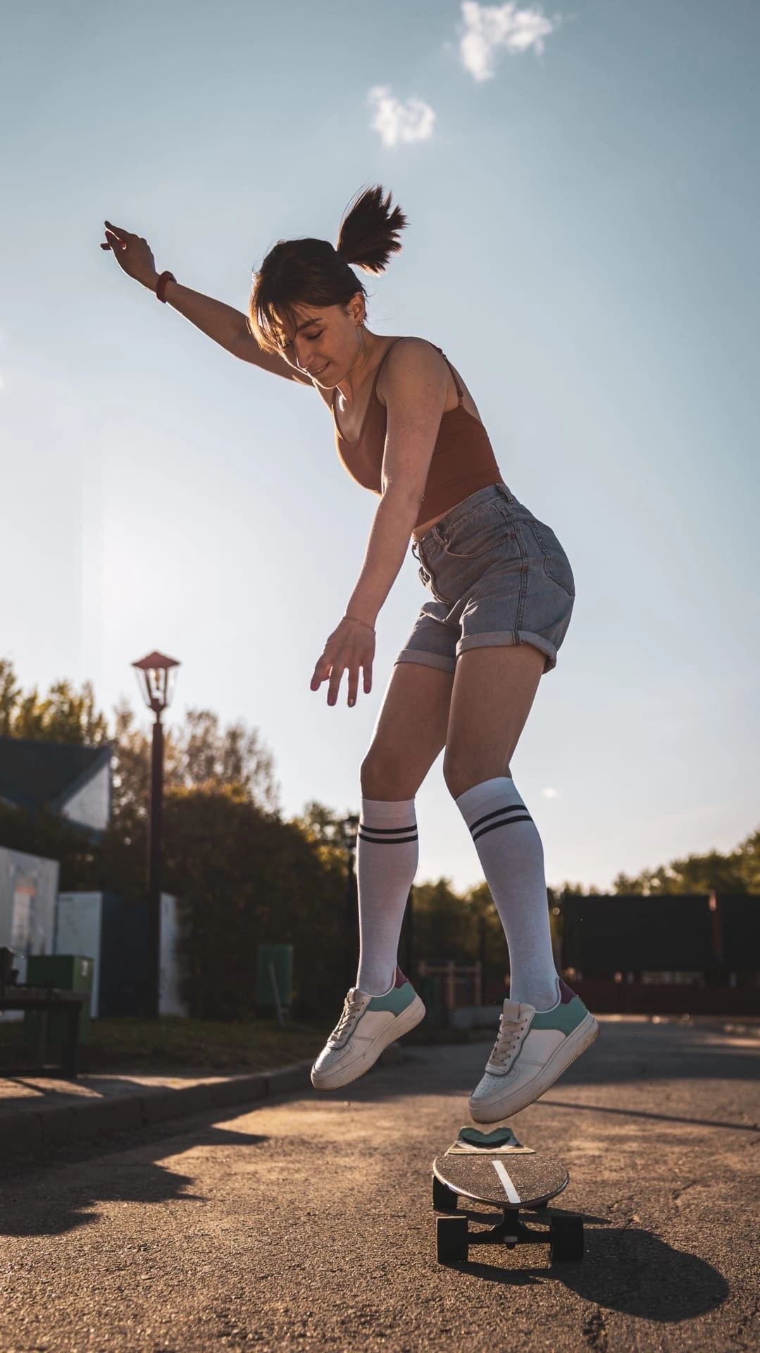 Фотосессия девушка в коротких шортах катается на скейте