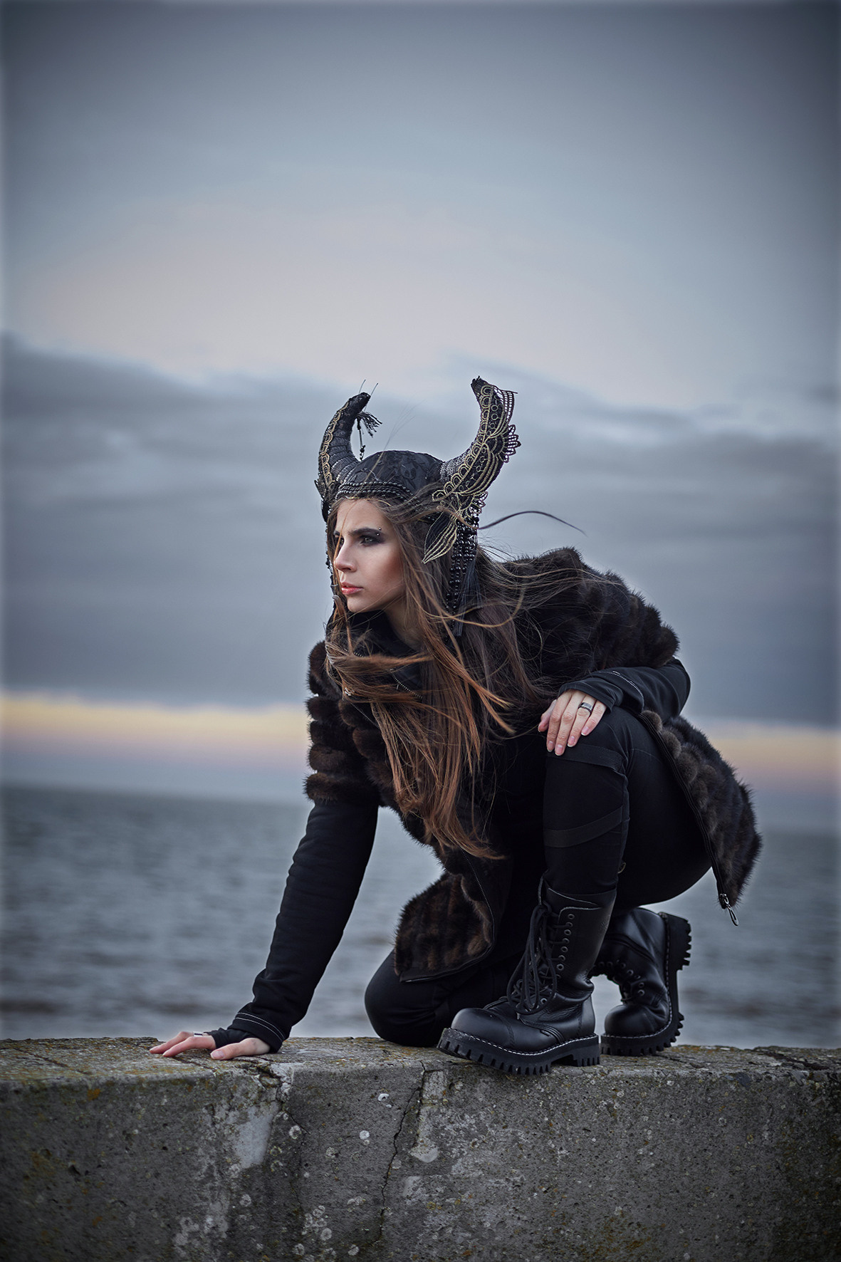 Фэшн портрет девушки в стиле викинга на фоне море в час заката. Морской ветер развевает волосы девушки в головном уборе с рогами. Головной убор с рогами. Фотограф. Тимашевск. Кубань. Краснодарский край.
