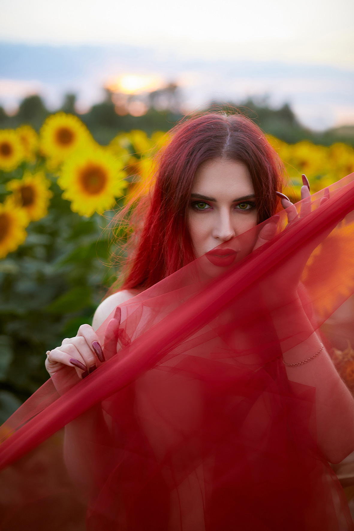 Портрет красивой девушки с красными волосами в красной ткани в поле с цветущими подсолнухами. Фотограф. Тимашевск. Кубань. Краснодарский край.