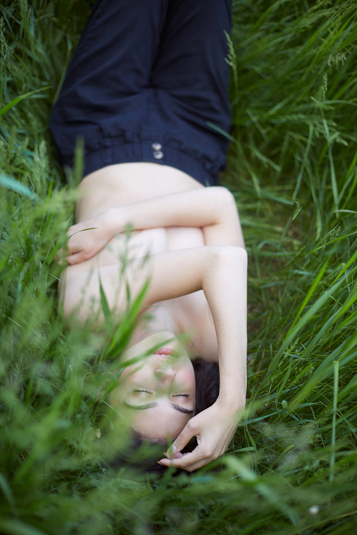 Девушка топлес лежит в луговой траве. Девушка в черных штанах. Нежность. Портрет девушки в траве. Фотограф. Тимашевск. Кубань. Краснодарский край.