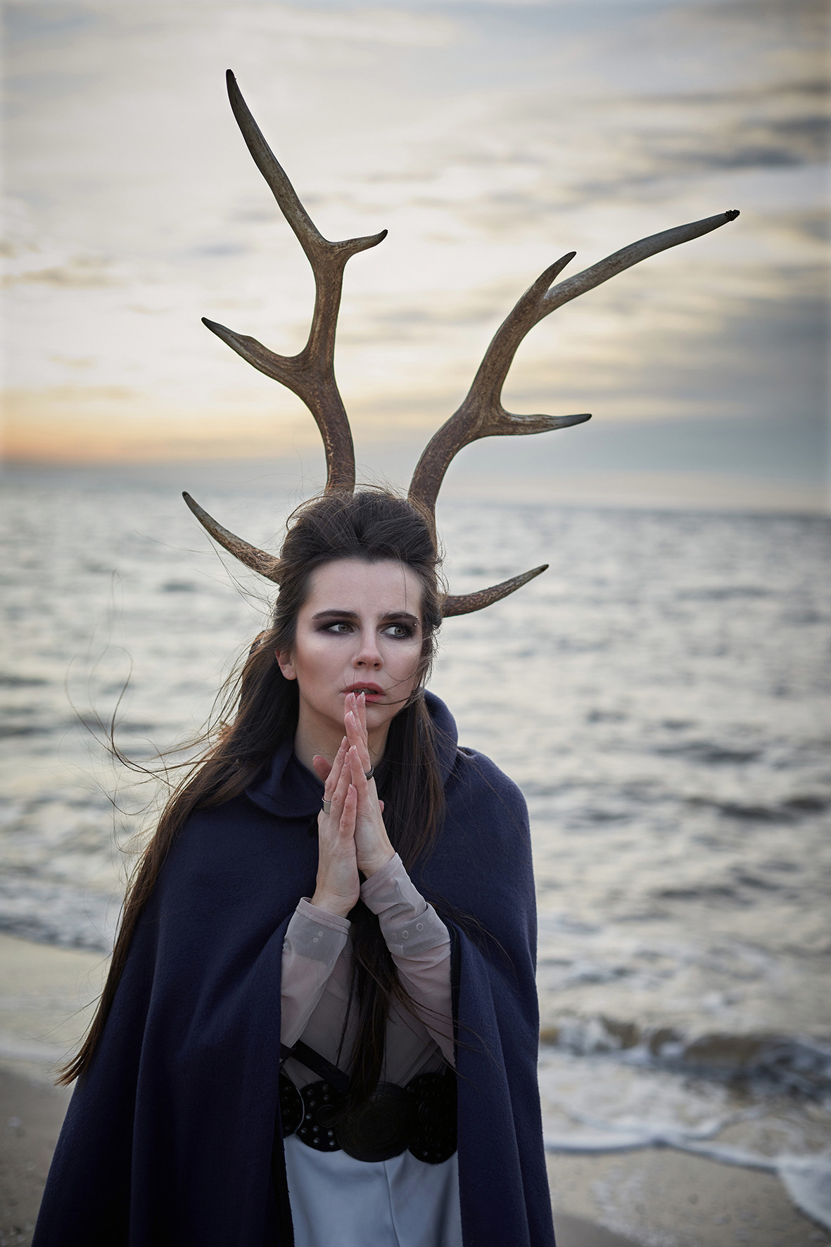 Художественная съемка на берегу моря. Девушка в образе шамана с оленьими рогами, накидка развевается на ветру. Фотограф. Тимашевск. Кубань. Краснодарский край.