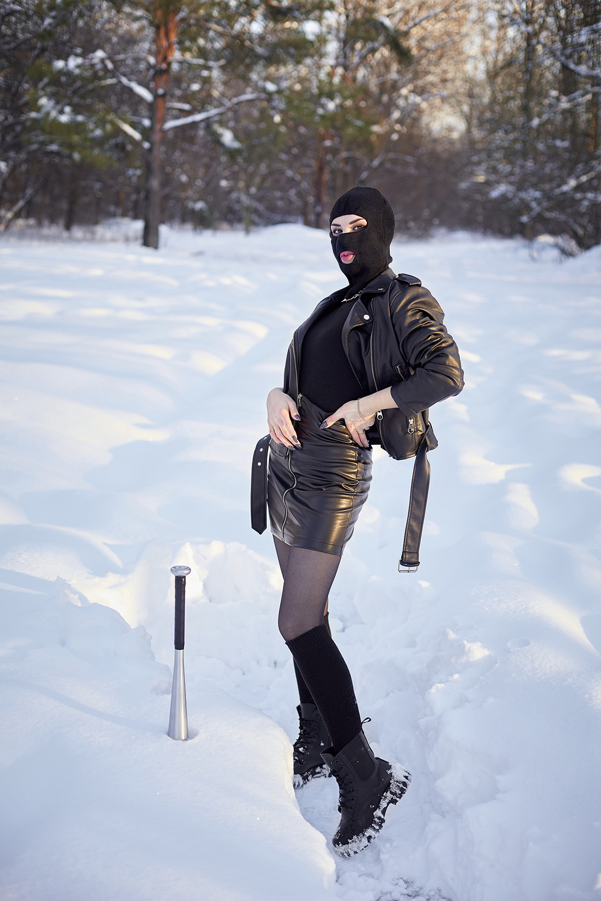 Криминальная дерзкая девушка в кожаной одежде и балаклаве на голове. Девушка с битой. Девушка в образе бандита в заснеженном лесу. Фотограф. Тимашевск. Кубань. Краснодарский край.