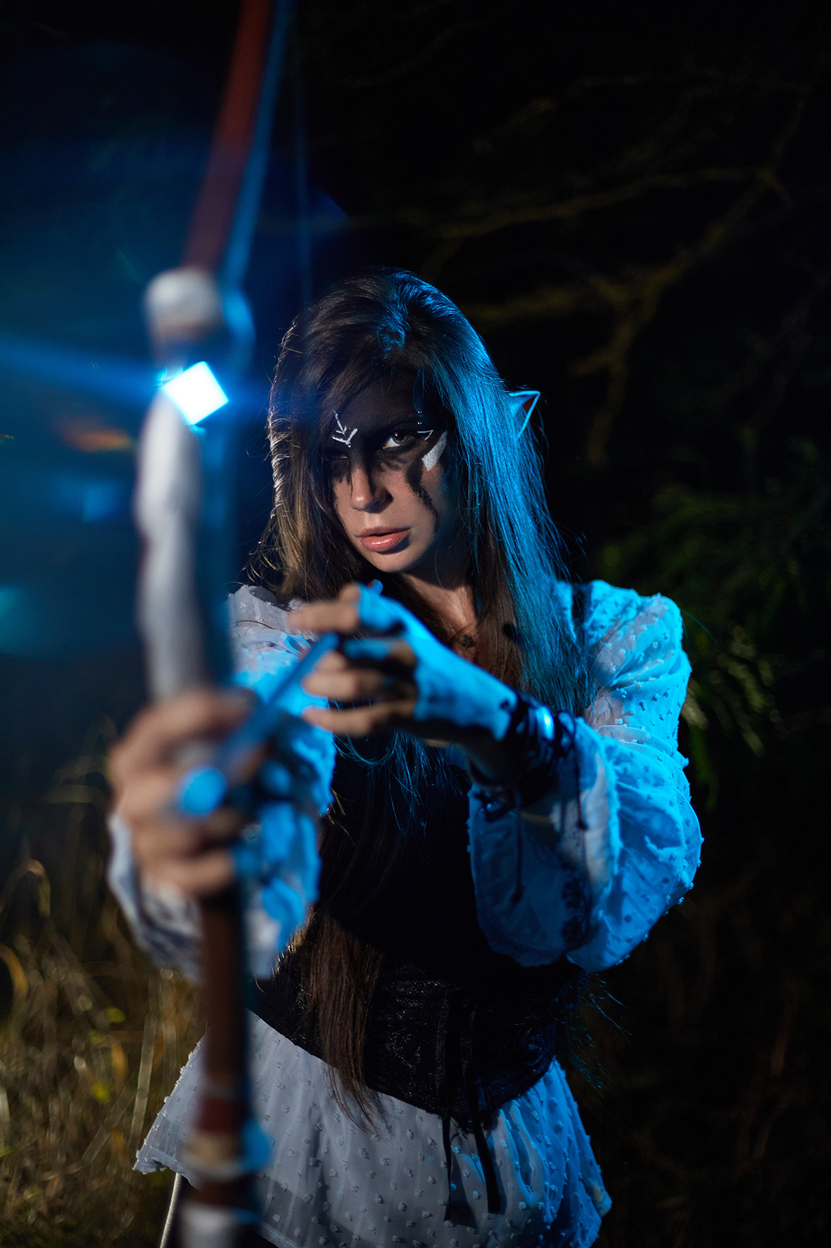 Боевой эльф с черным макияжем с луком и стрелой в руках стоит в ночном лесу. Фотограф. Фотоискусство. Краснодарский край. Кубань. Тимашевск.