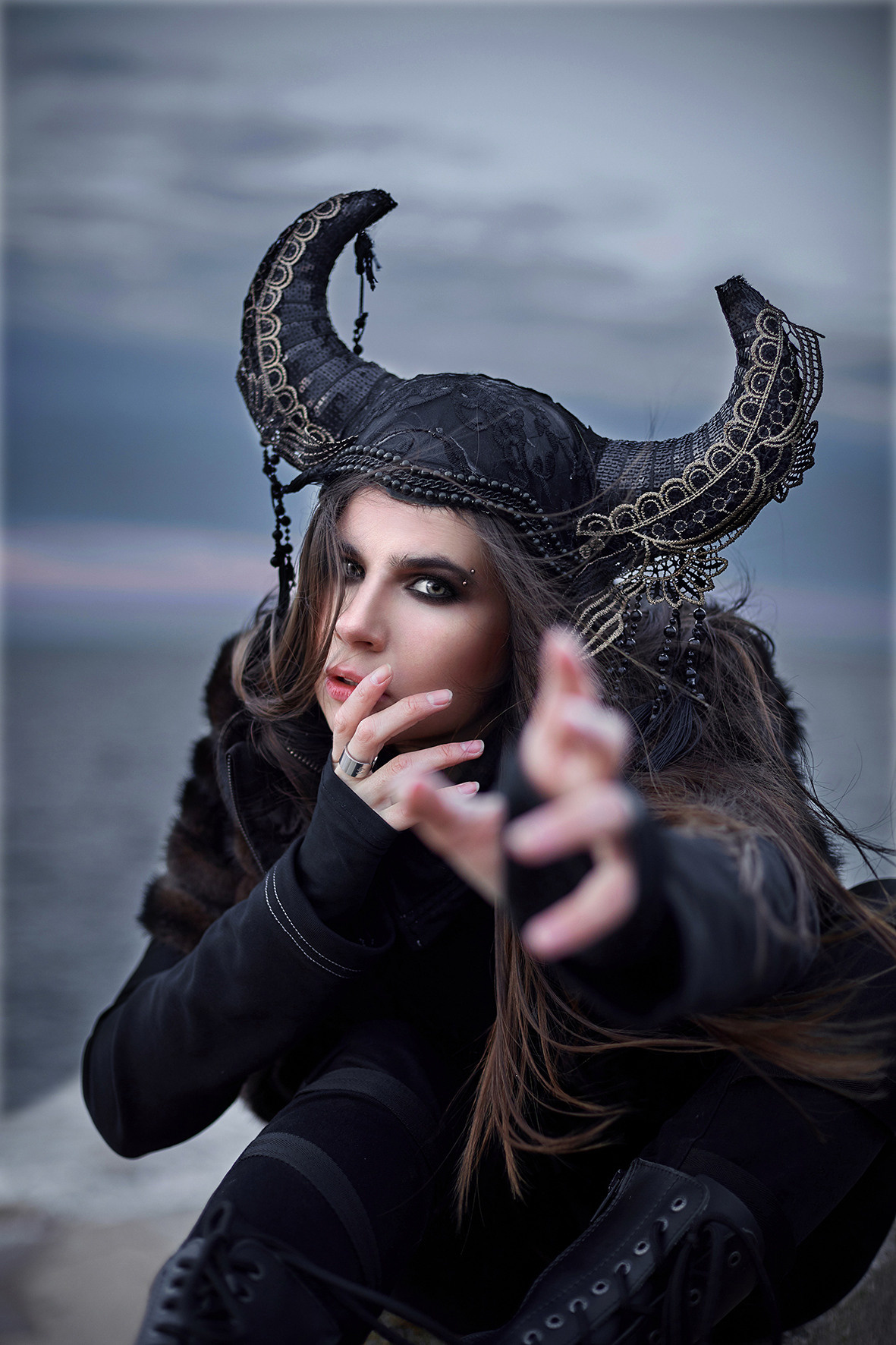 Фэшн портрет девушки в стиле викинга на фоне море в час заката. Морской ветер развевает волосы девушки в головном уборе с рогами. Головной убор с рогами. Фотограф. Тимашевск. Кубань. Краснодарский край.