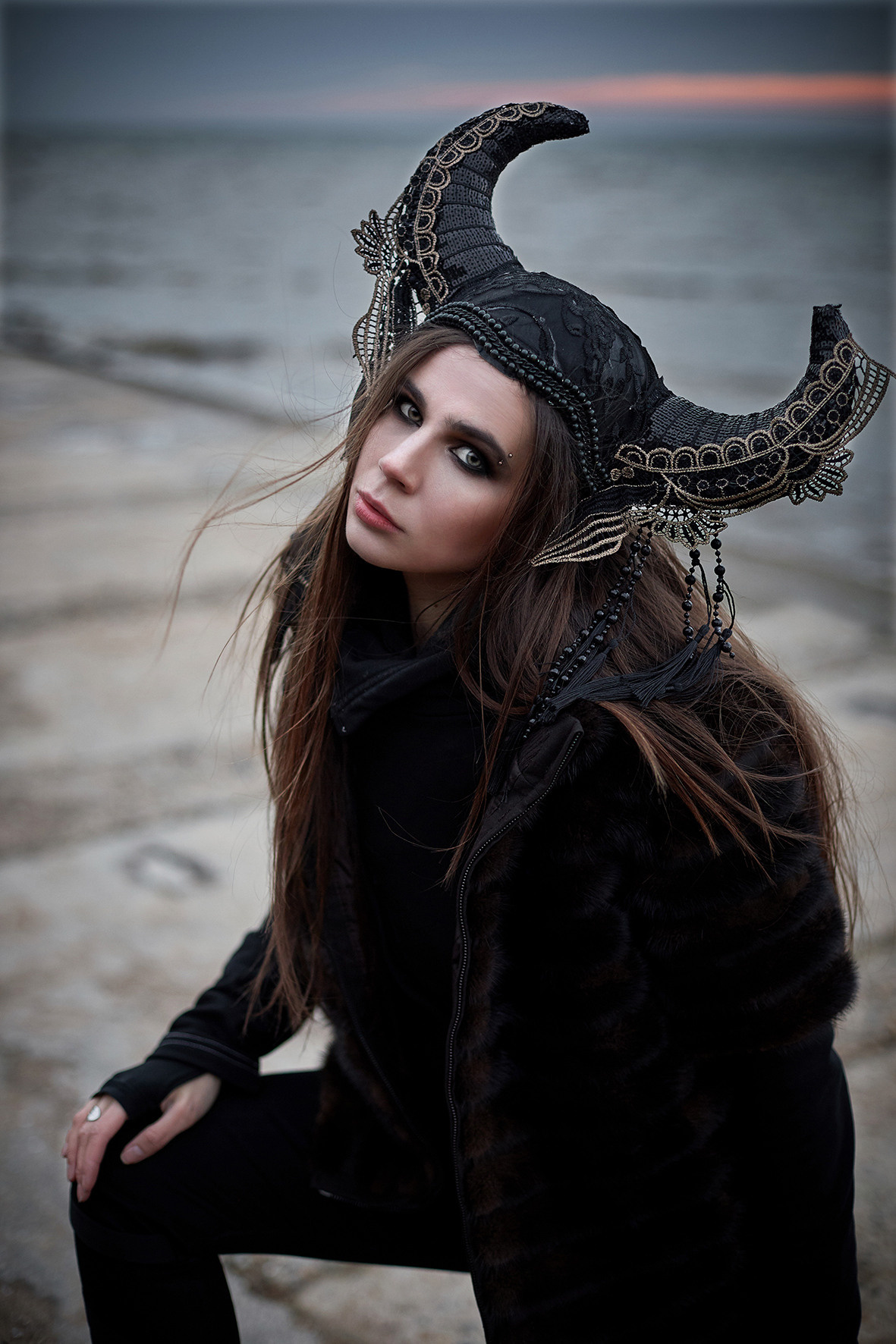 Фэшн портрет девушки в стиле викинга на фоне море в час заката. Морской ветер развевает волосы девушки в головном уборе с рогами. Головной убор с рогами. Фотограф. Тимашевск. Кубань. Краснодарский край.