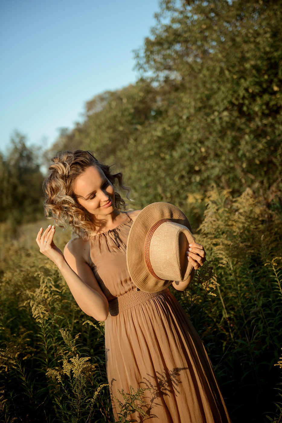 A photo shoot for a woman l in the field. Sunset photo shoot for a girl Curly hair style. (photographer in Edinburgh Elena)