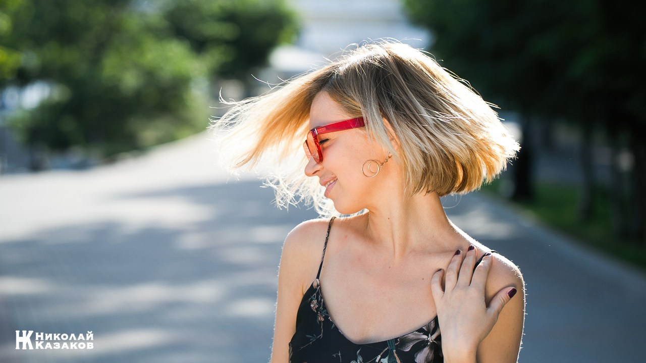 Активная молодая женщина с развевающимися волосами на утренней прогудке по городу.