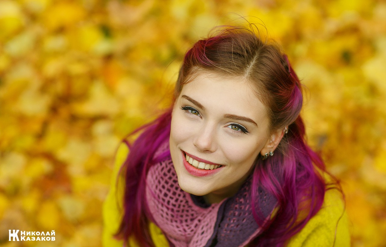 Счастливый портрет яркой девушки на фоне осенней листвы