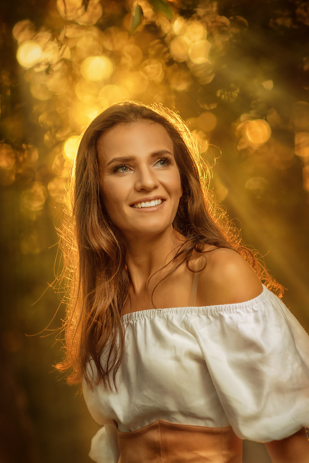 Девушка в светлом платье. На заднем плане красивое закатное боке.