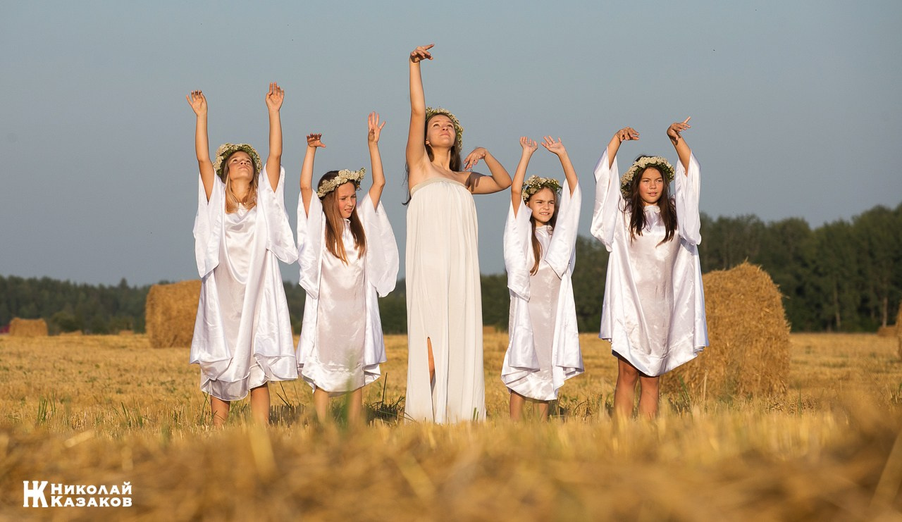 Стройные девочки подростки танцуют в пшеничном поле во время фотосессии на закате.