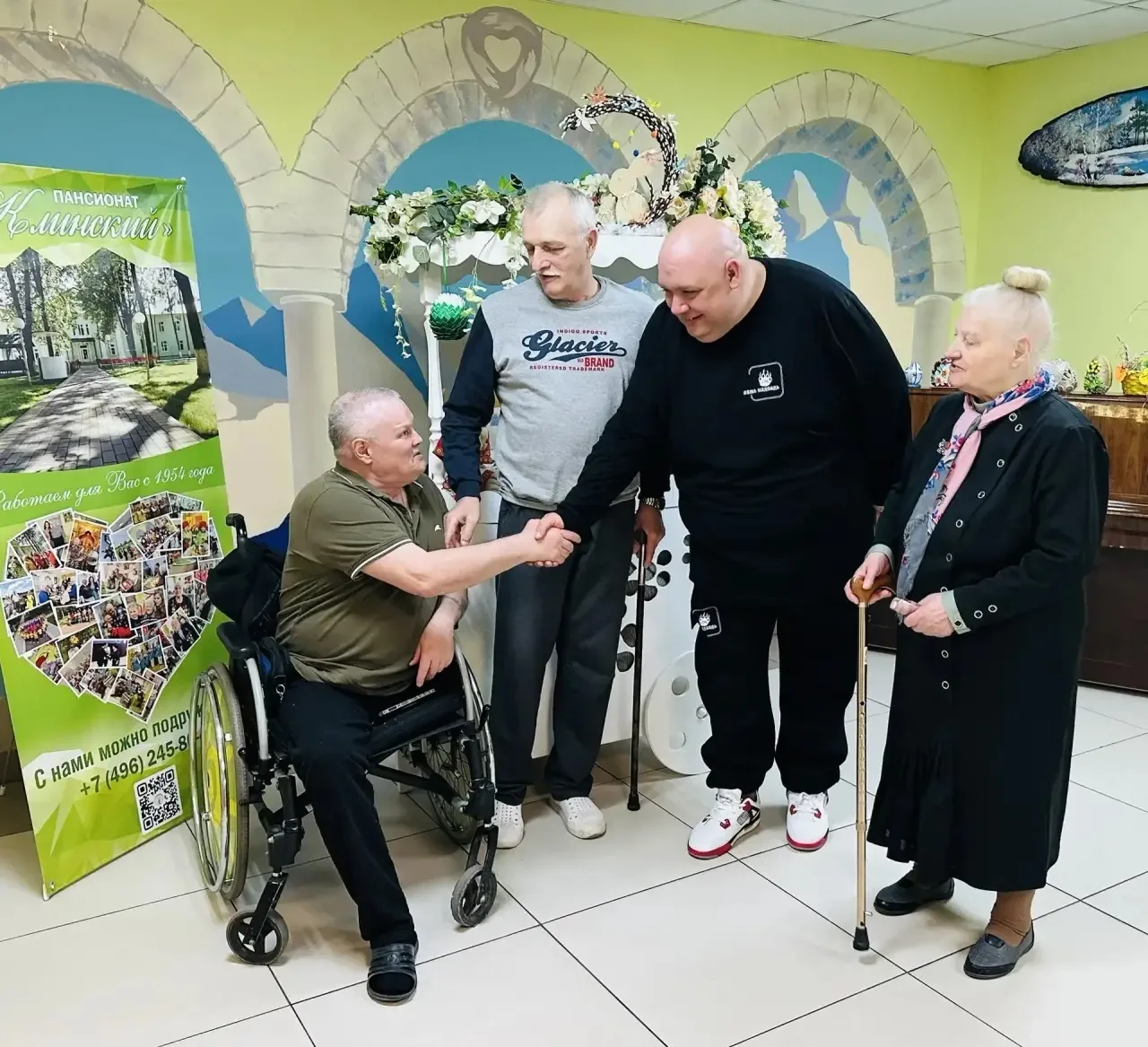 Лёша Медведь фотографируется с гостями с ОВЗ.