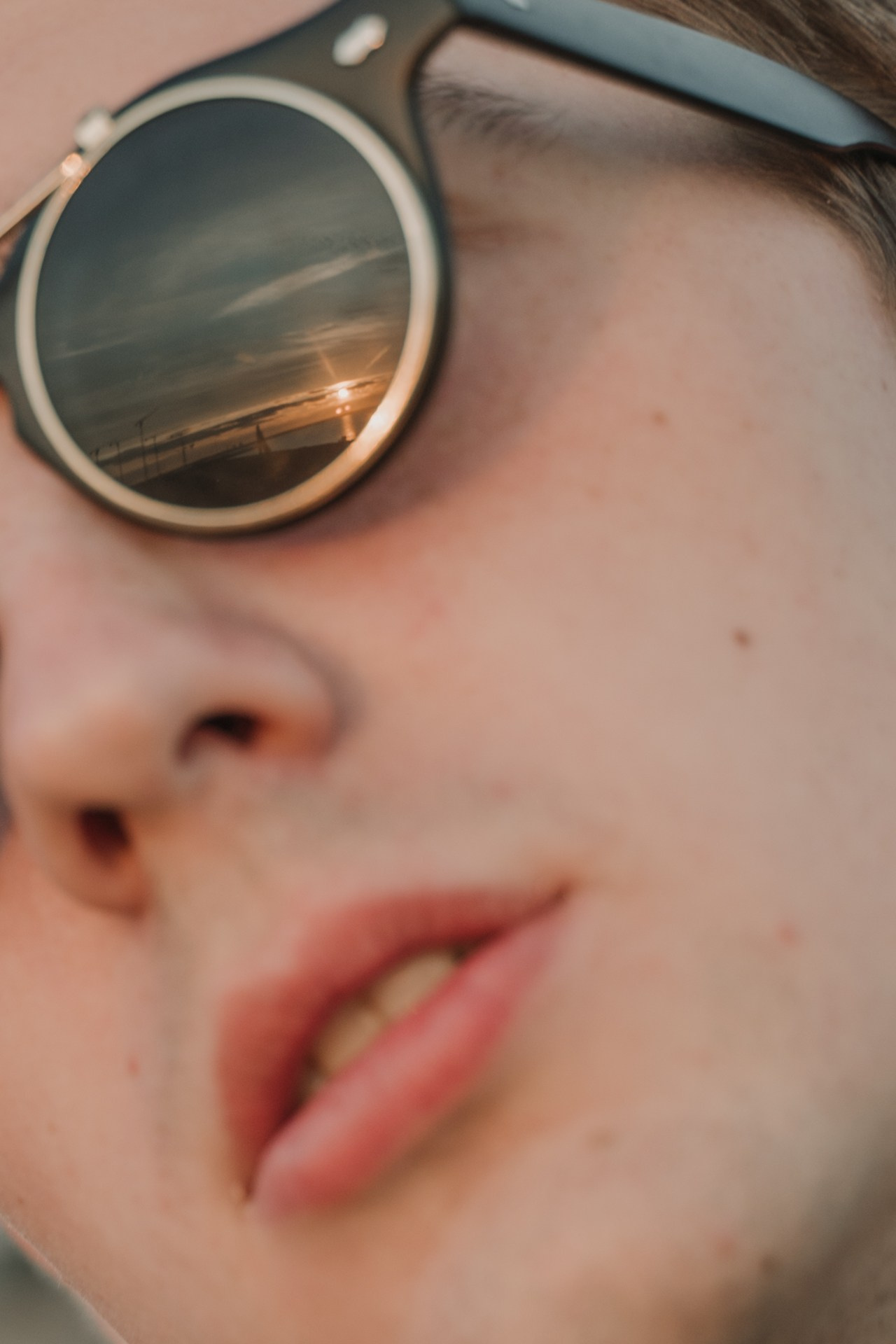 Детальный кадр парня с очками с закатным солнцем